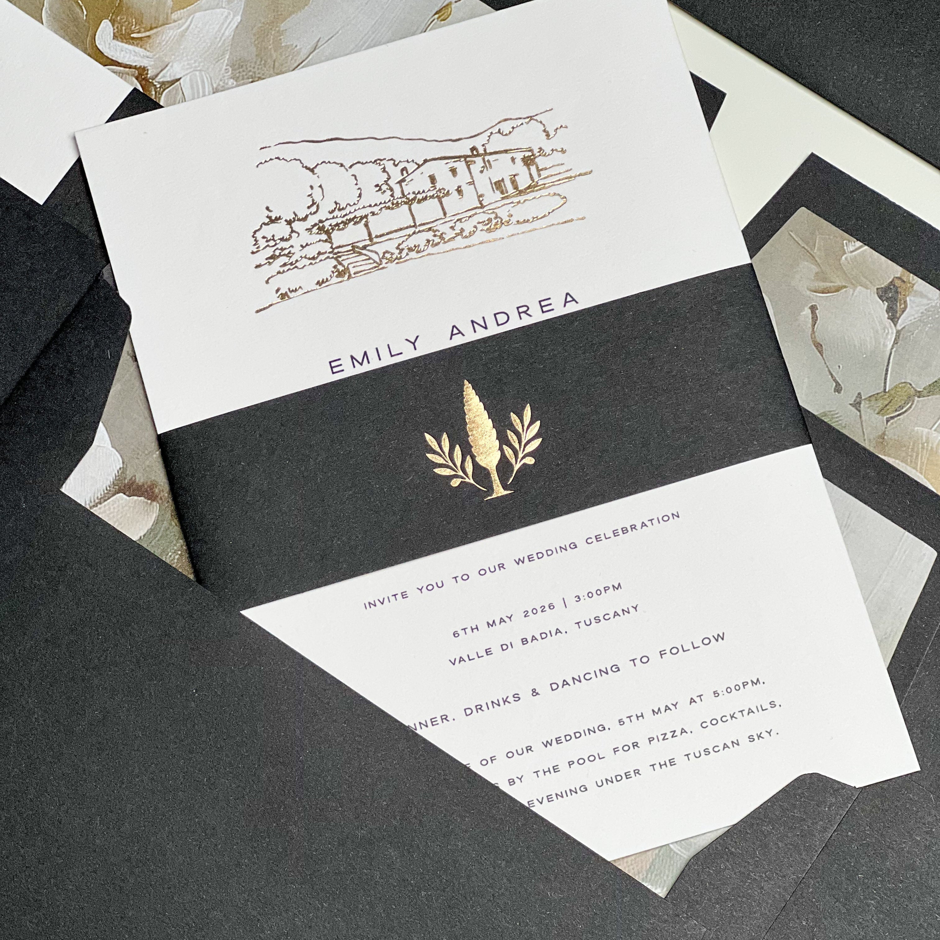 Black and Gold foil wedding invitation with foil wedding venue sketch, laid flat across black envelope with printed envelope liners