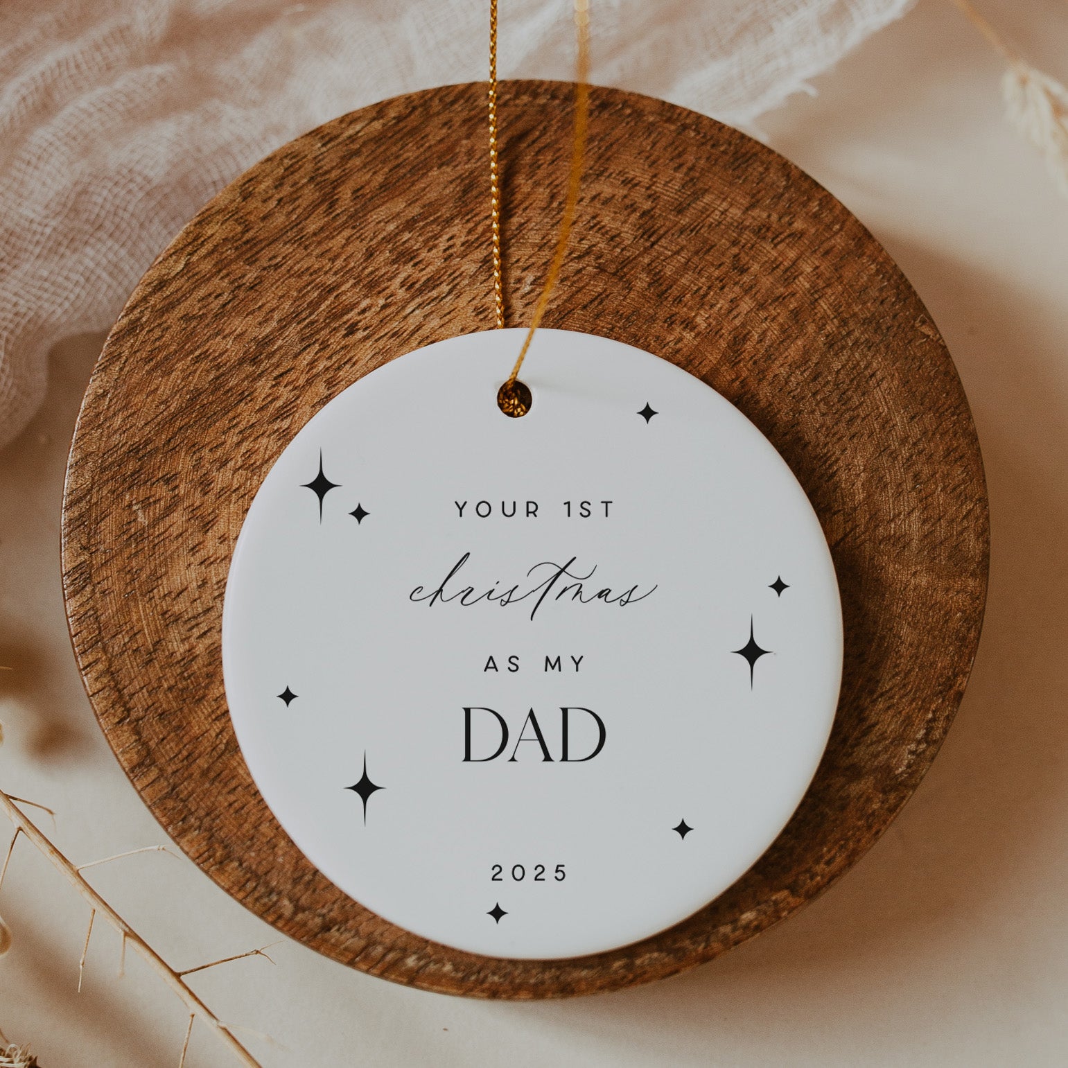 Round wooden plaque with a white label reading 'Your 1st Christmas as my Dad 2025' on a soft beige background.