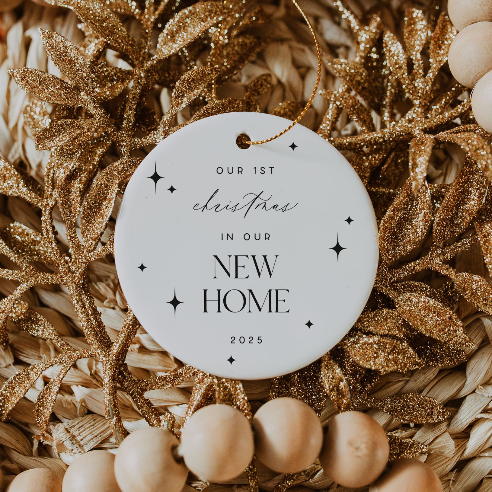 Decorative ornament with 'Our 1st Christmas in Our New Home 2025' text on a gold and beige background.