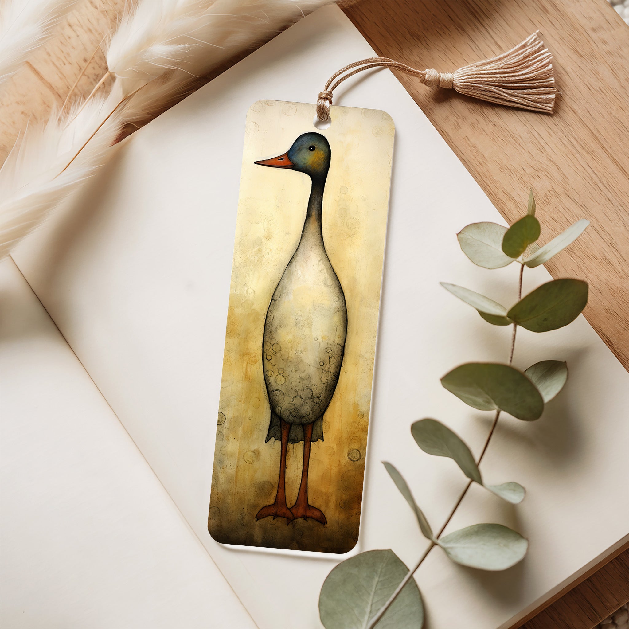 Bookmark with duck illustration on a wooden surface with eucalyptus leaves