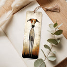 Bookmark with dog illustration on a wooden surface with eucalyptus leaves