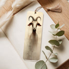 Acrylic  bookmark with goat illustration on a wooden surface with eucalyptus leaves