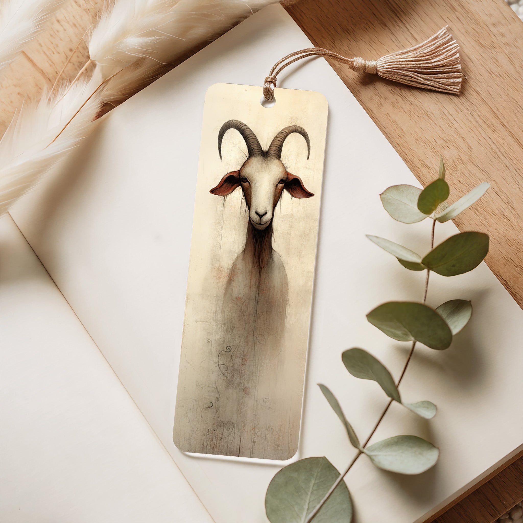 Acrylic  bookmark with goat illustration on a wooden surface with eucalyptus leaves