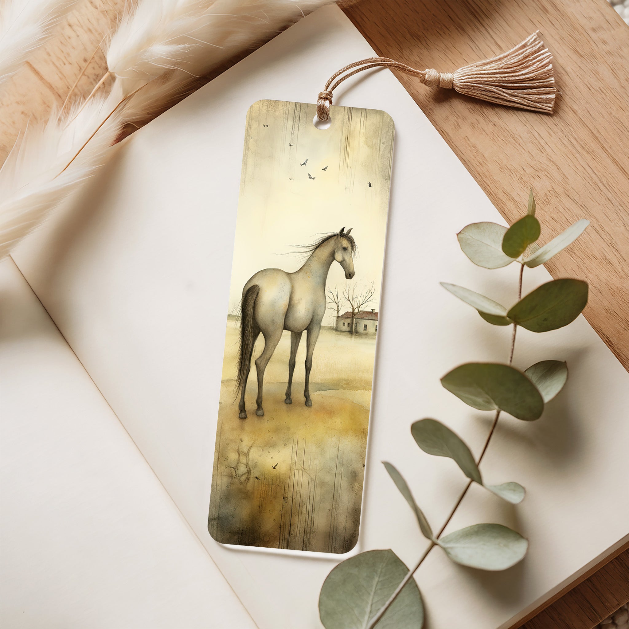 Bookmark with horse illustration on a wooden surface with eucalyptus leaves
