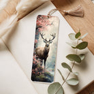 Decorative bookmark with a deer design on a wooden surface with leaves.