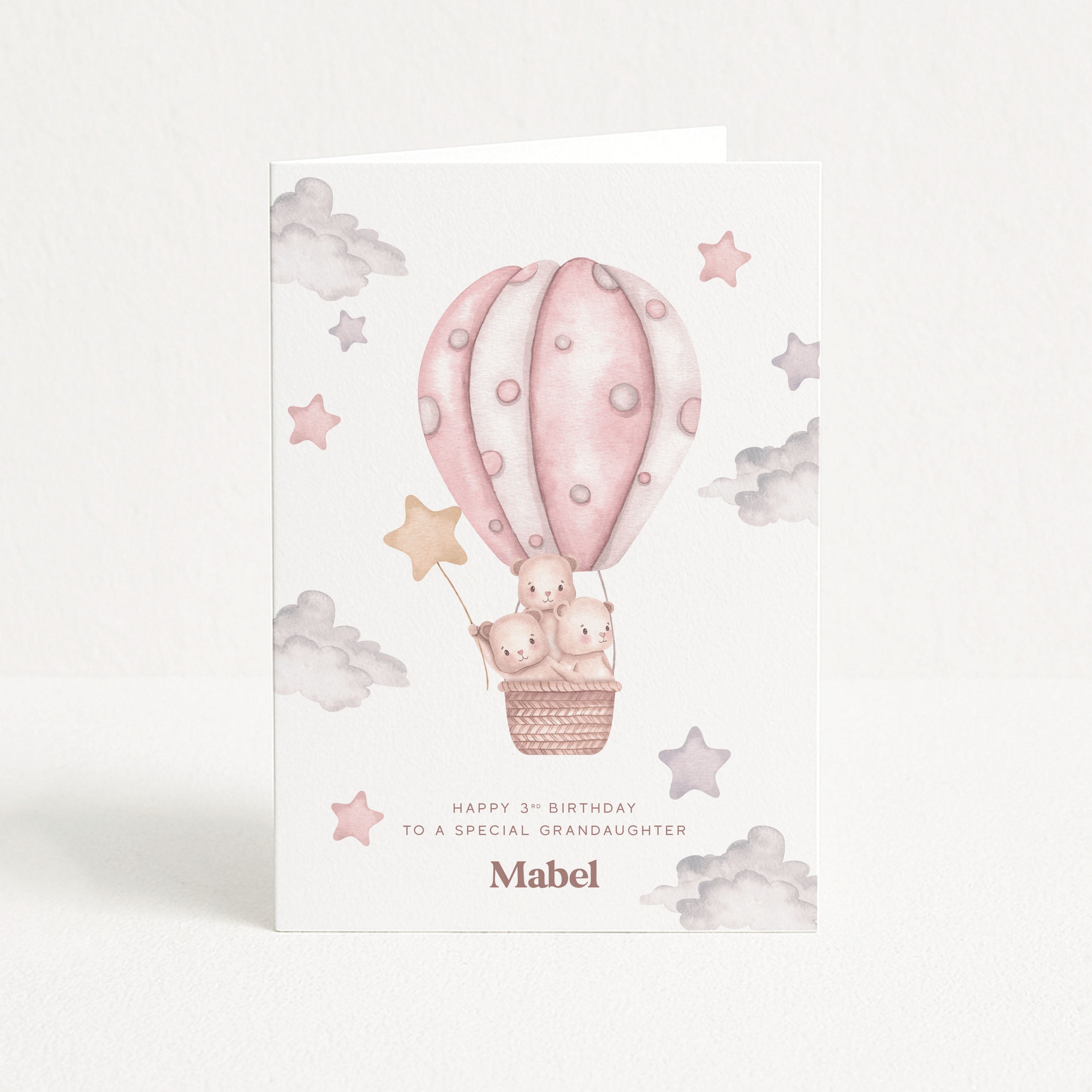 Greeting card with pink hot air balloon and teddy bears on a white background