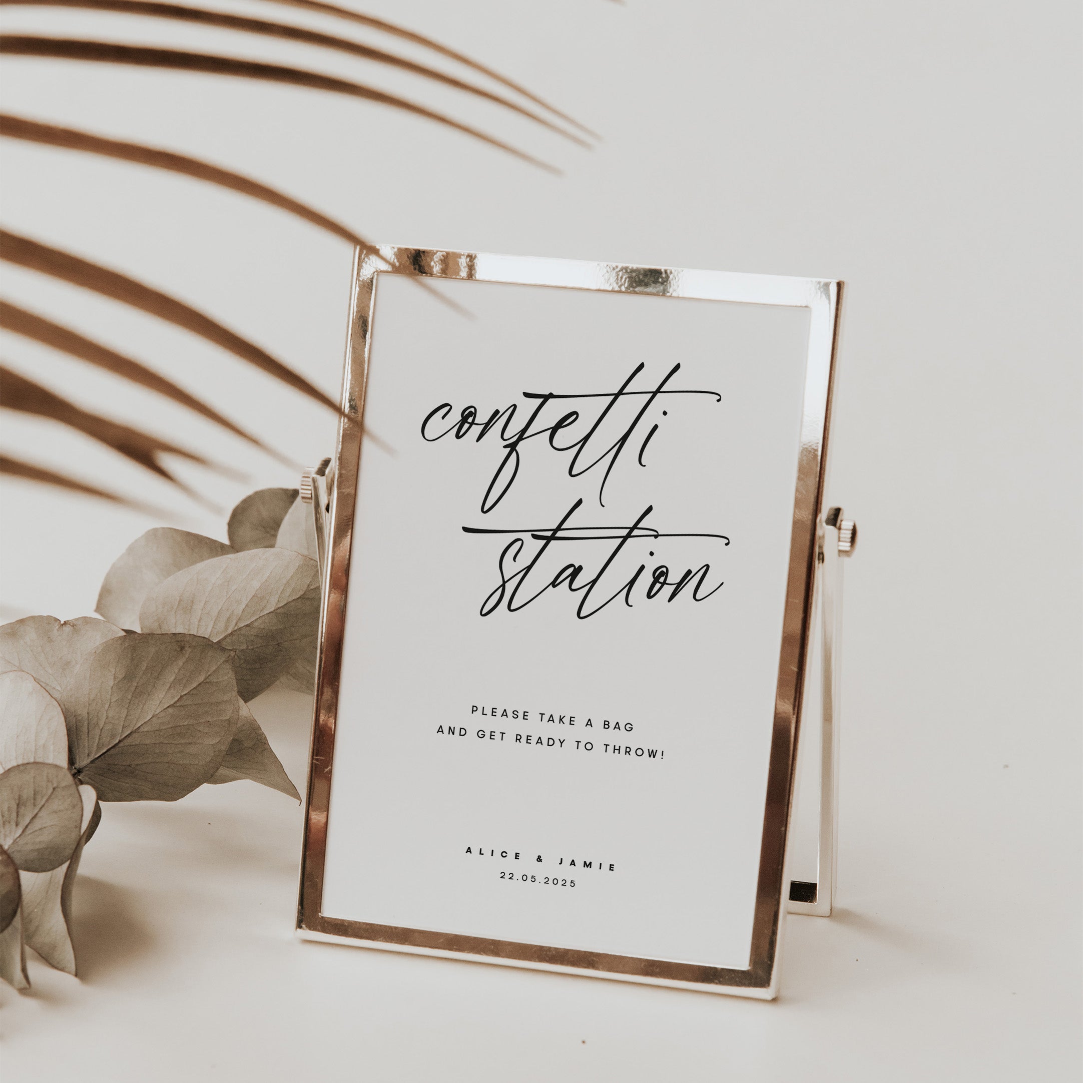 Confetti sign for wedding reception in rose gold frame and floral background