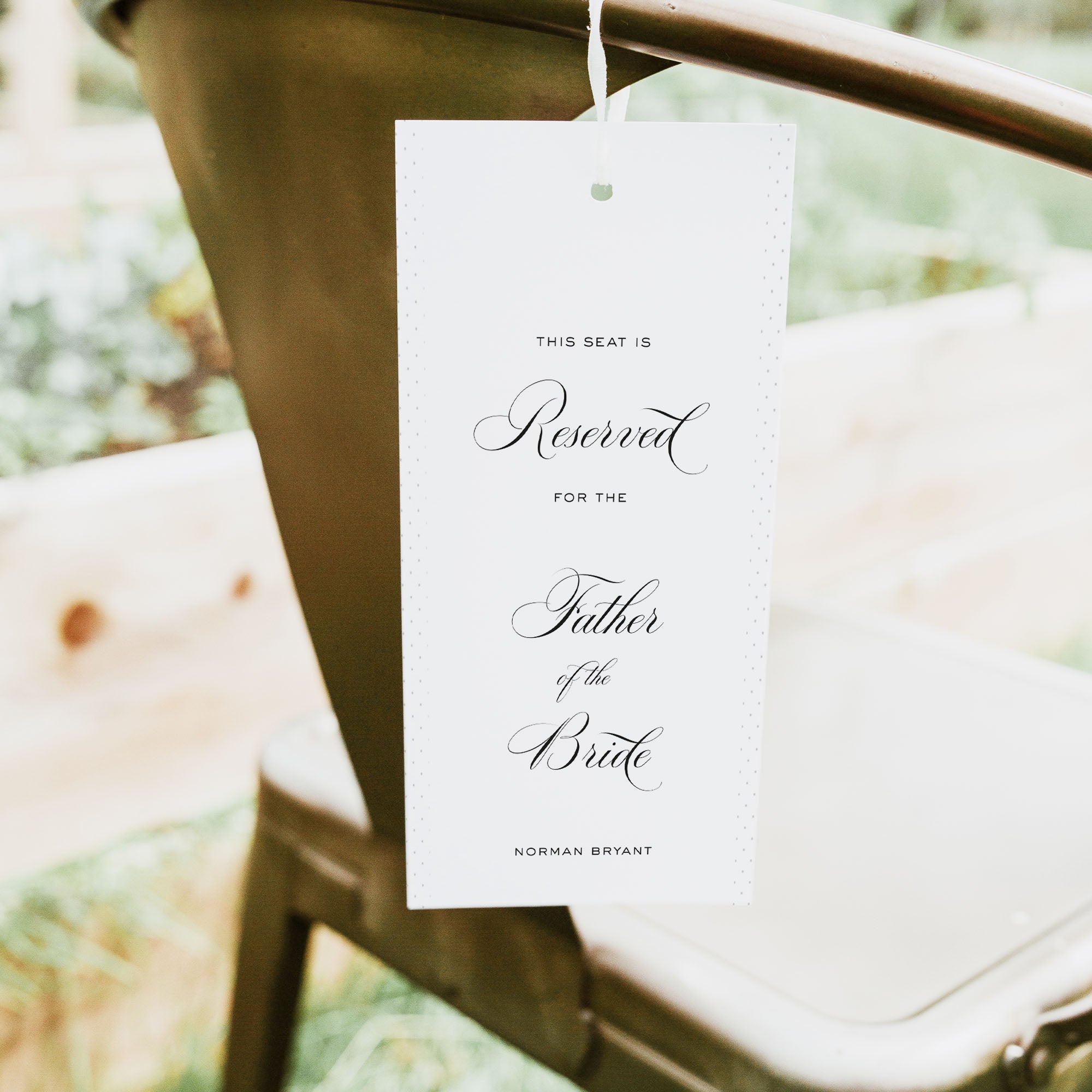 Reserved seat tag for the Father of the Bride at a wedding, hanging on a chair.