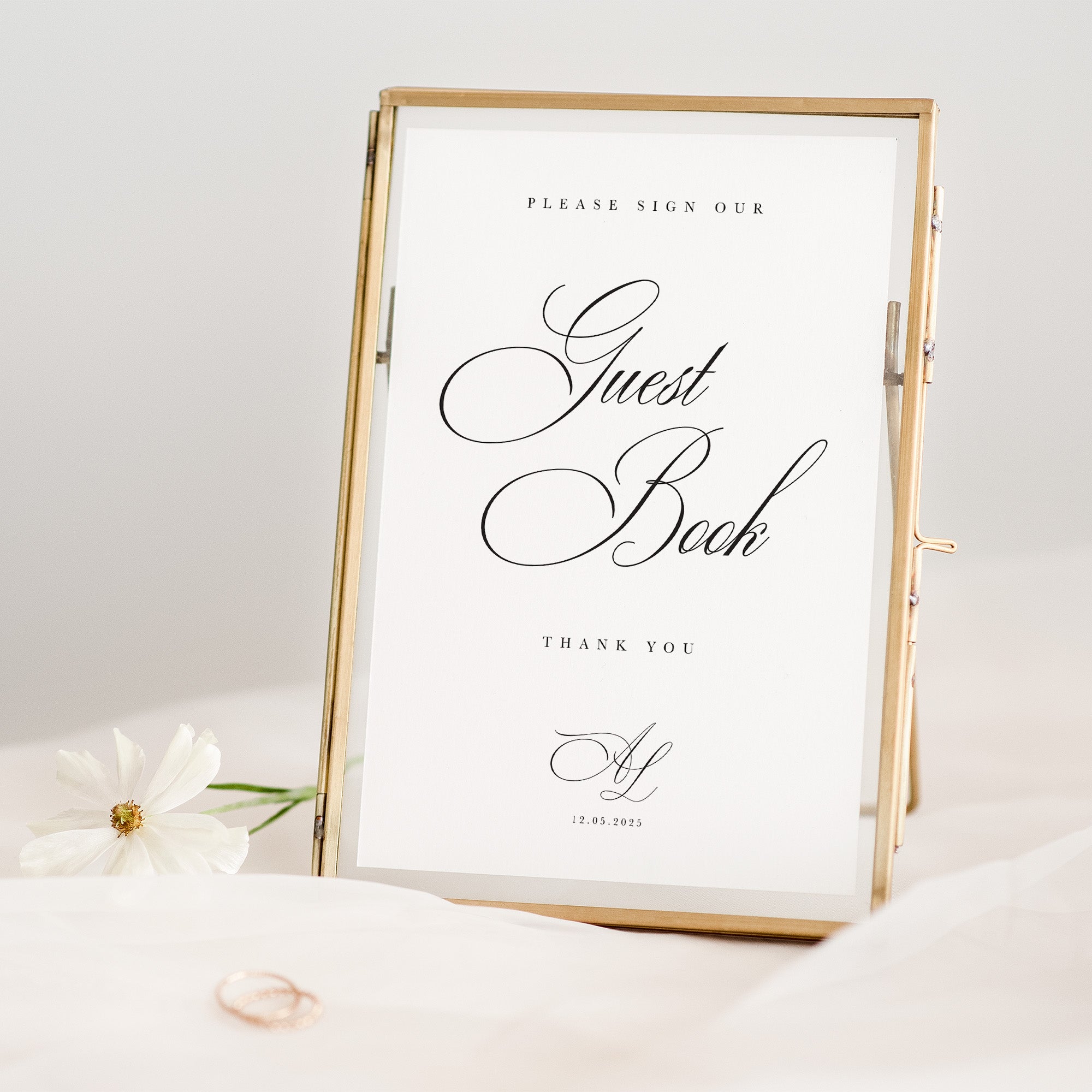 Guest book sign with gold frame on a white surface