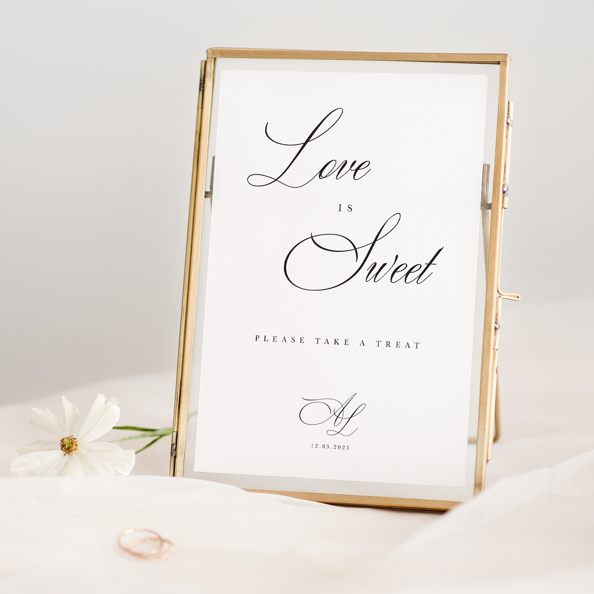 Decorative sign with 'Love is Sweet' text in a gold frame on a white background