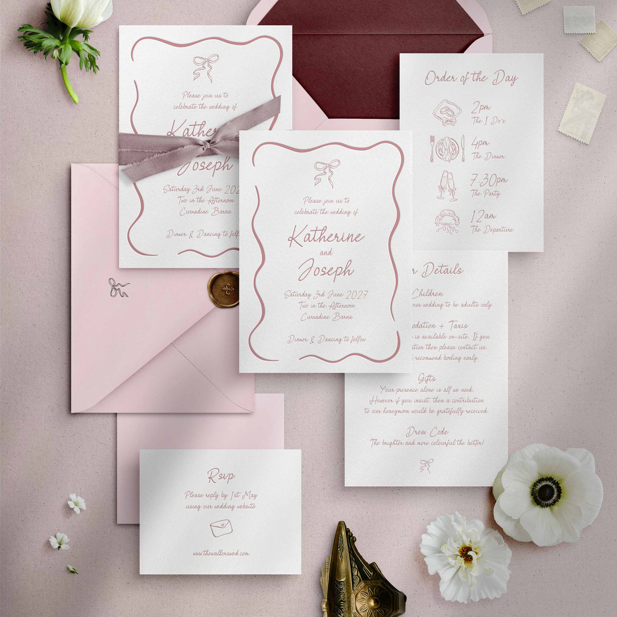 A flat lay of a letterpress wedding invitation suite in a white and pink colour scheme