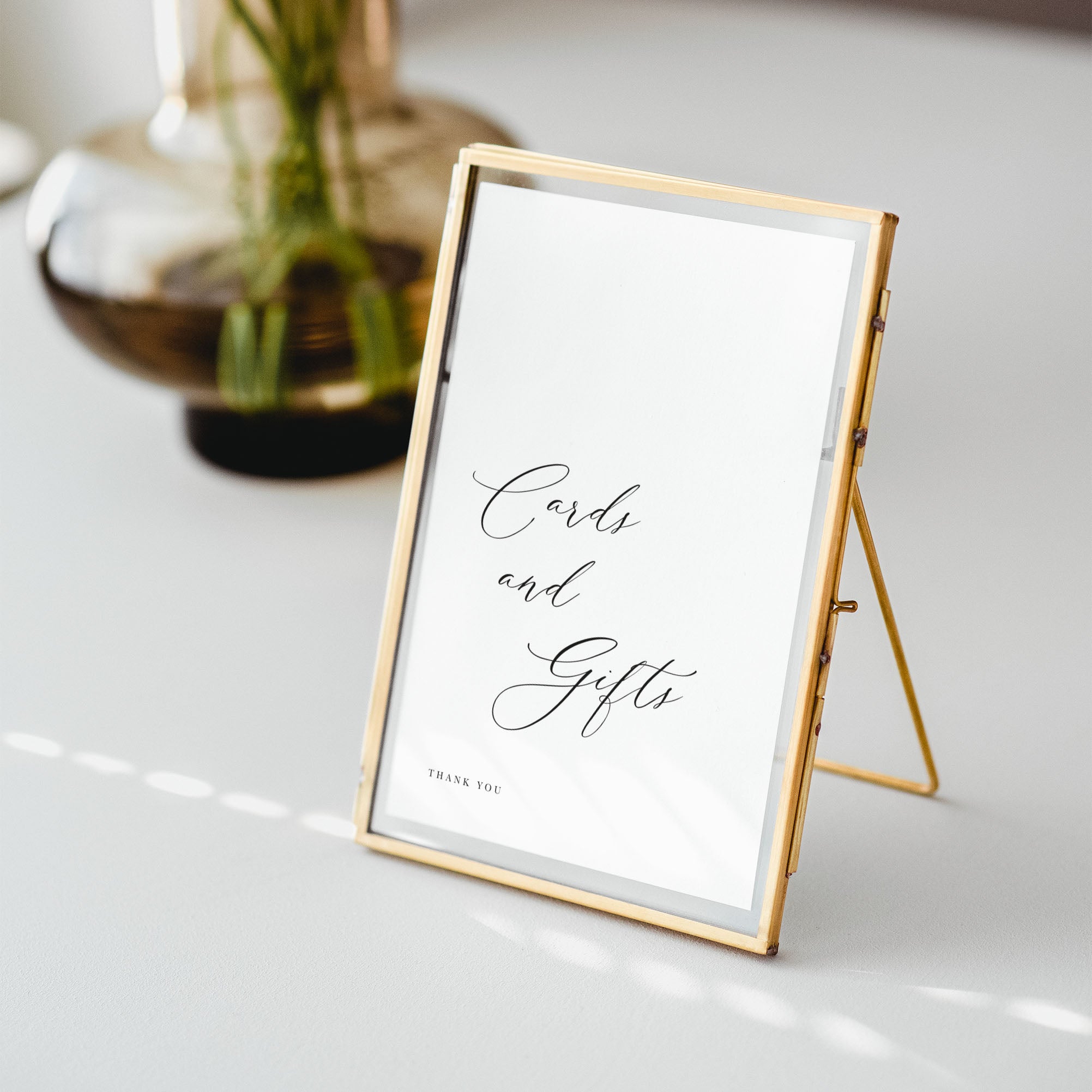 Gold-framed sign with 'Cards and Gifts' text on a white surface