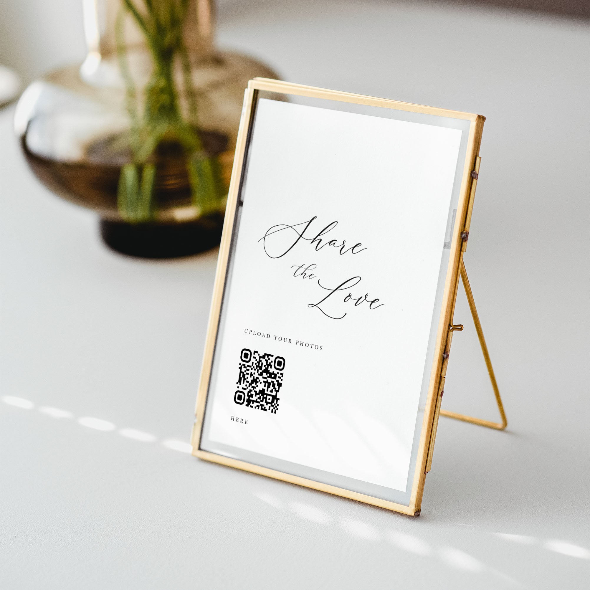 Gold frame with a QR code and 'Share the Love' text on a white surface