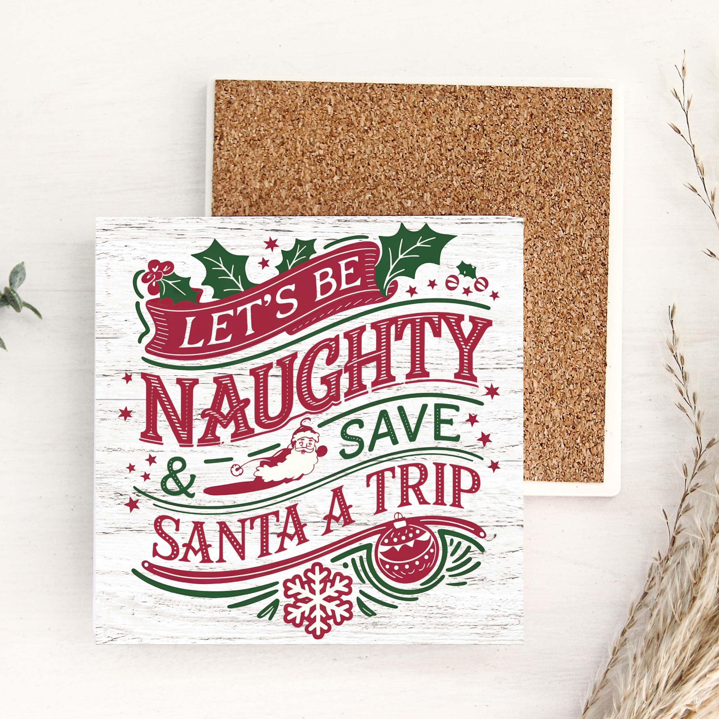 Christmas-themed coaster with decorative text on a white surface.