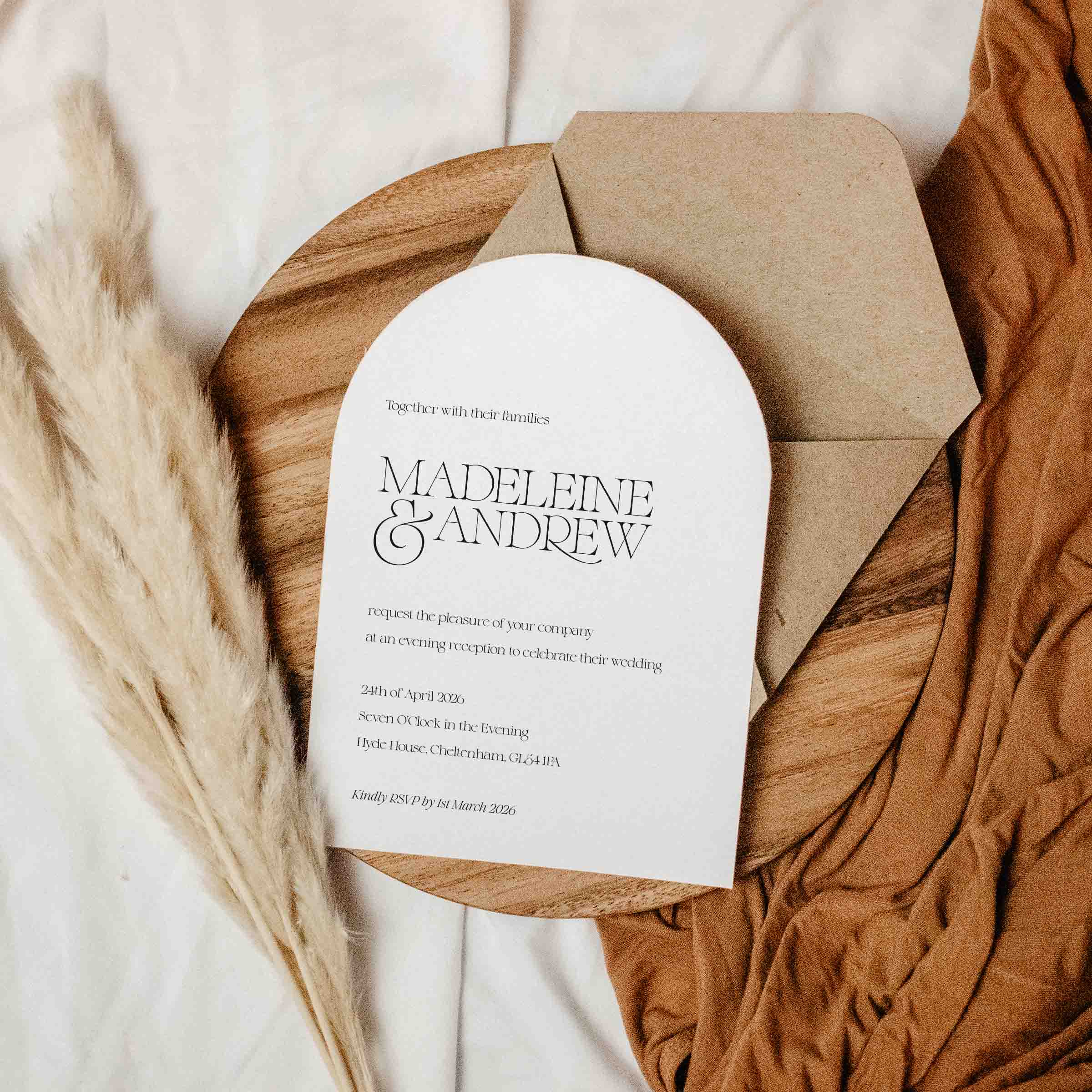 Arched Wedding invitation card with envelope on a textured surface with pampas grass