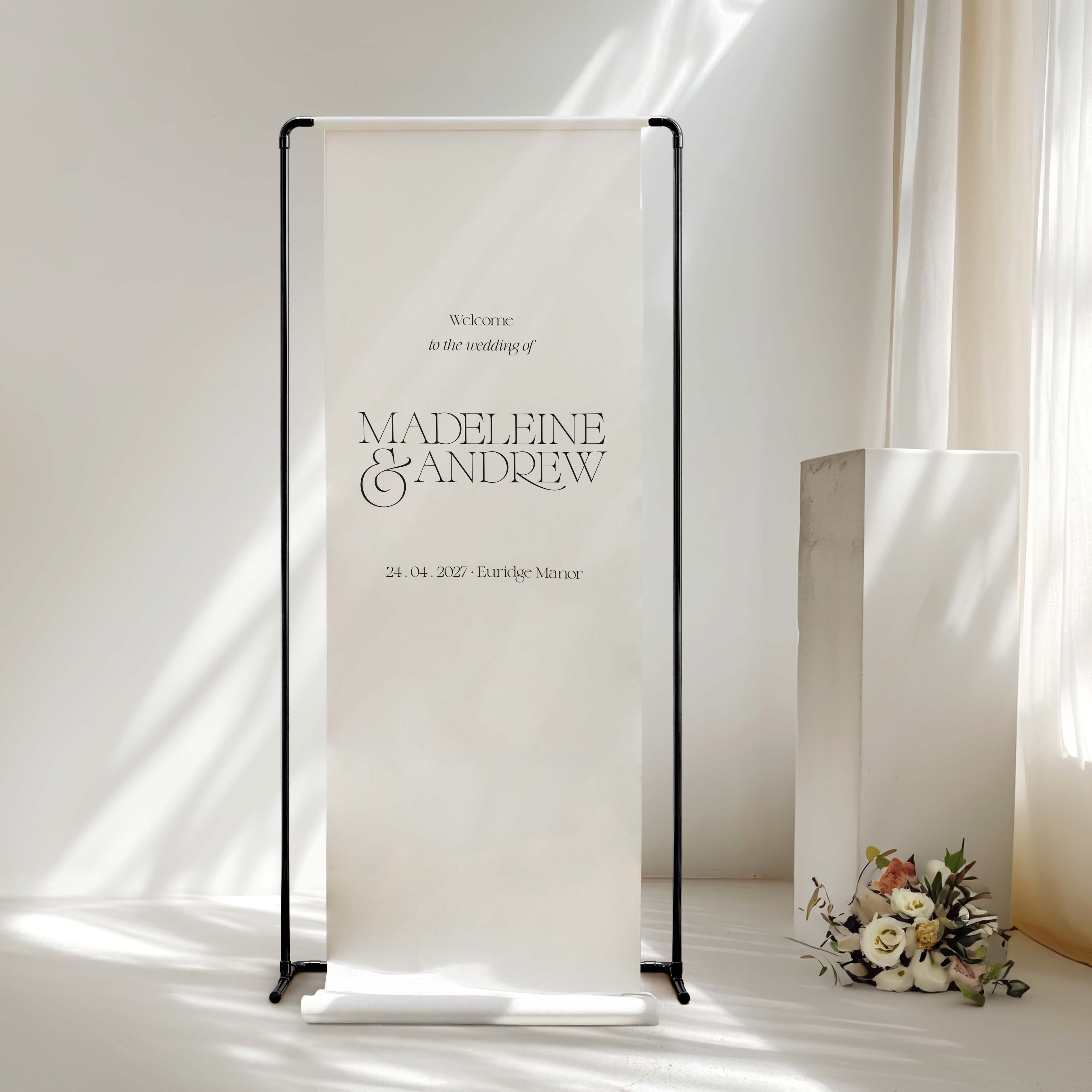 Wedding fabric welcome sign with 'Madeleine & Andrew' text in a minimalistic setting