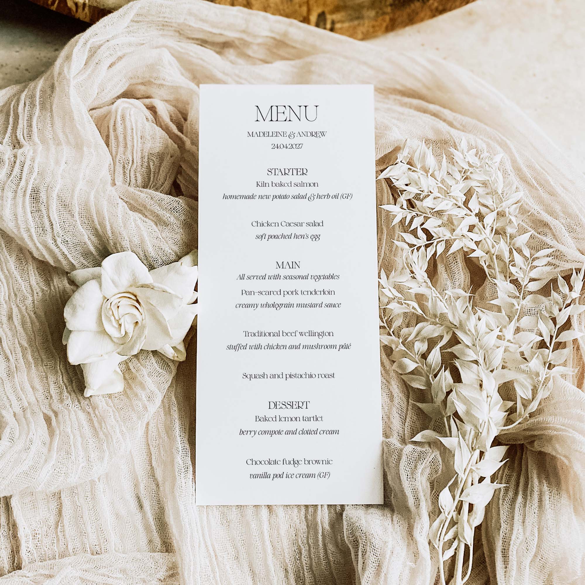 Menu card on a textured fabric surface with floral decorations