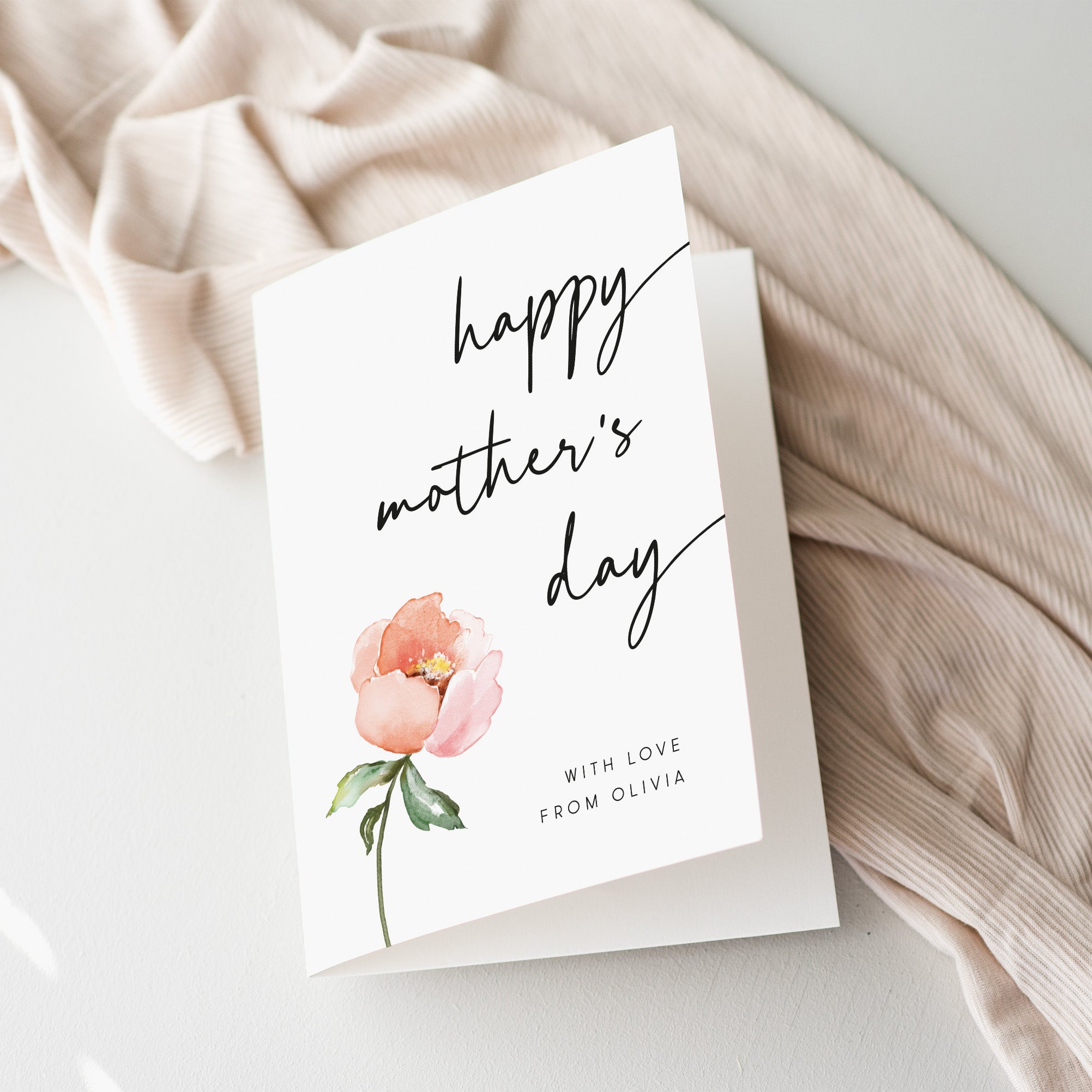 Mother's Day card with a pink flower on a soft fabric background