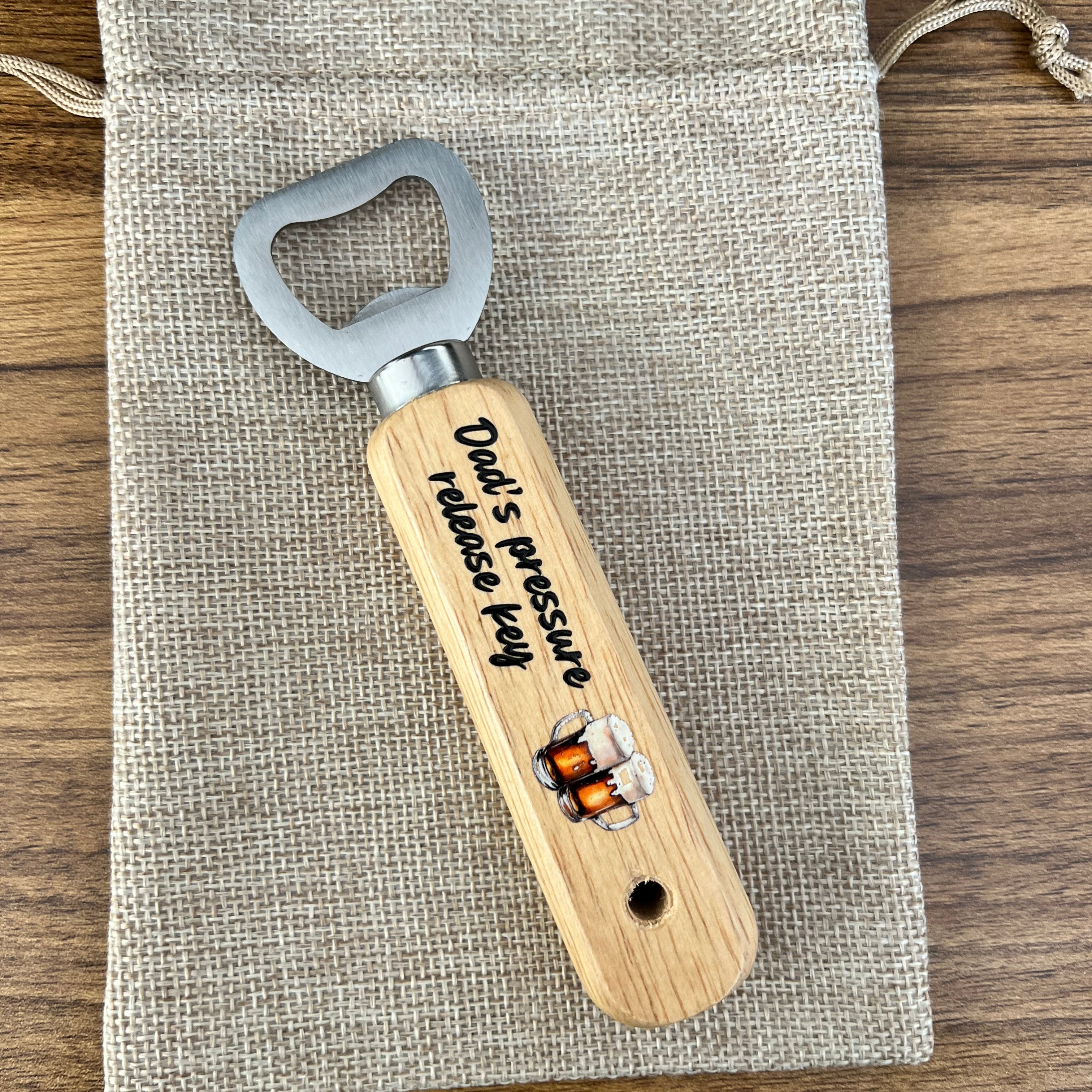 Wooden bottle opener with engraved text on a fabric pouch