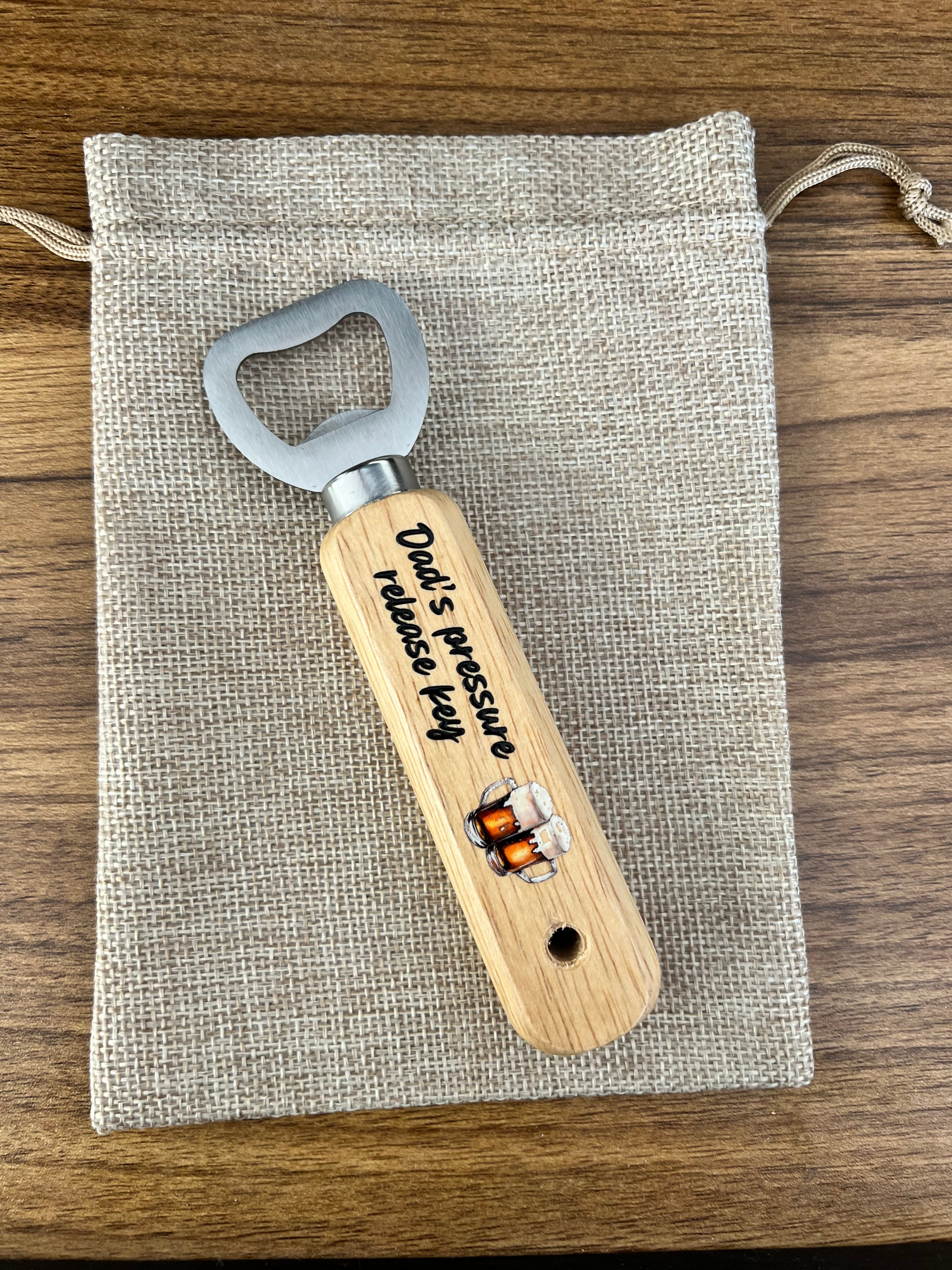 Wooden bottle opener with engraved text on a fabric pouch