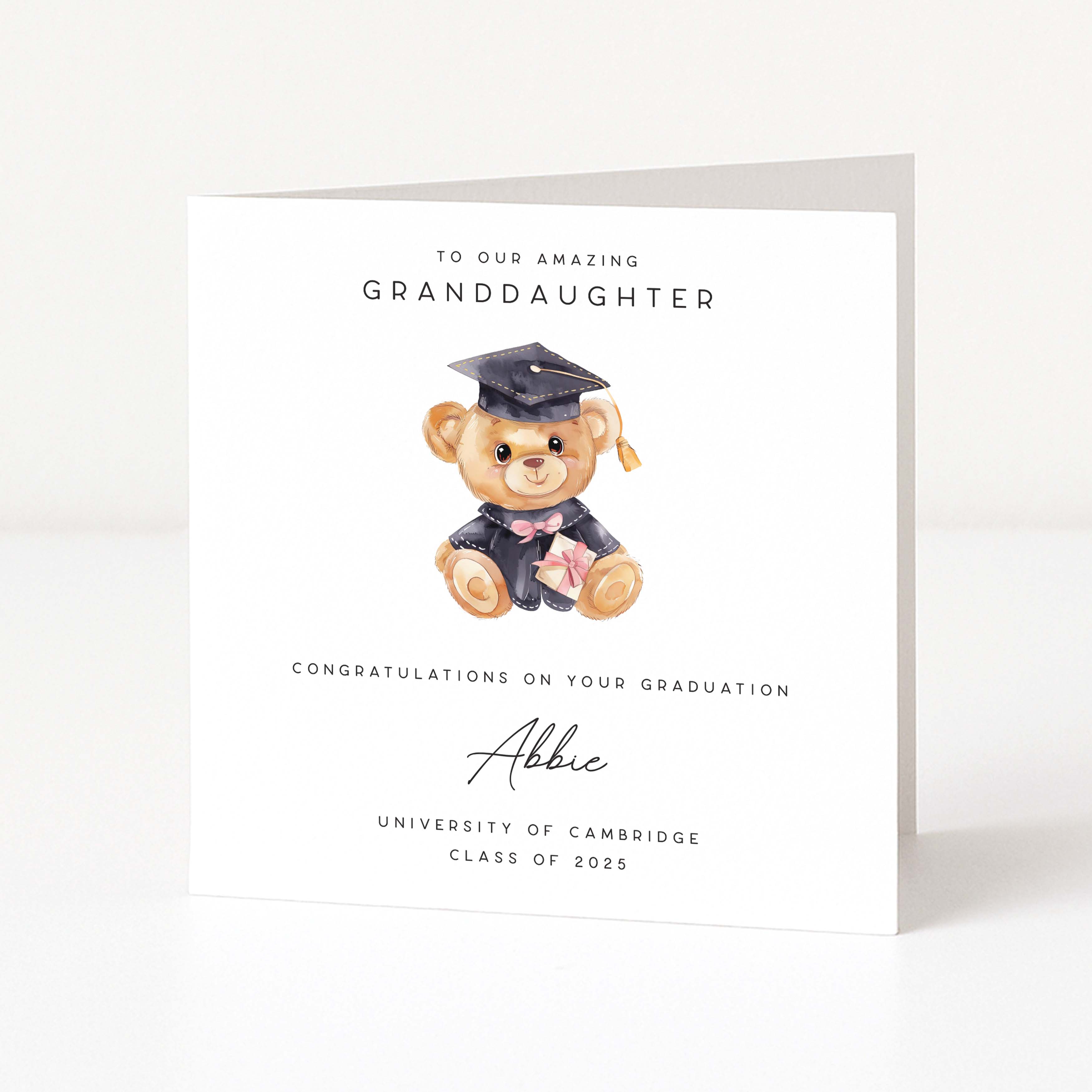 Graduation card with a teddy bear wearing a cap and gown on a white background
