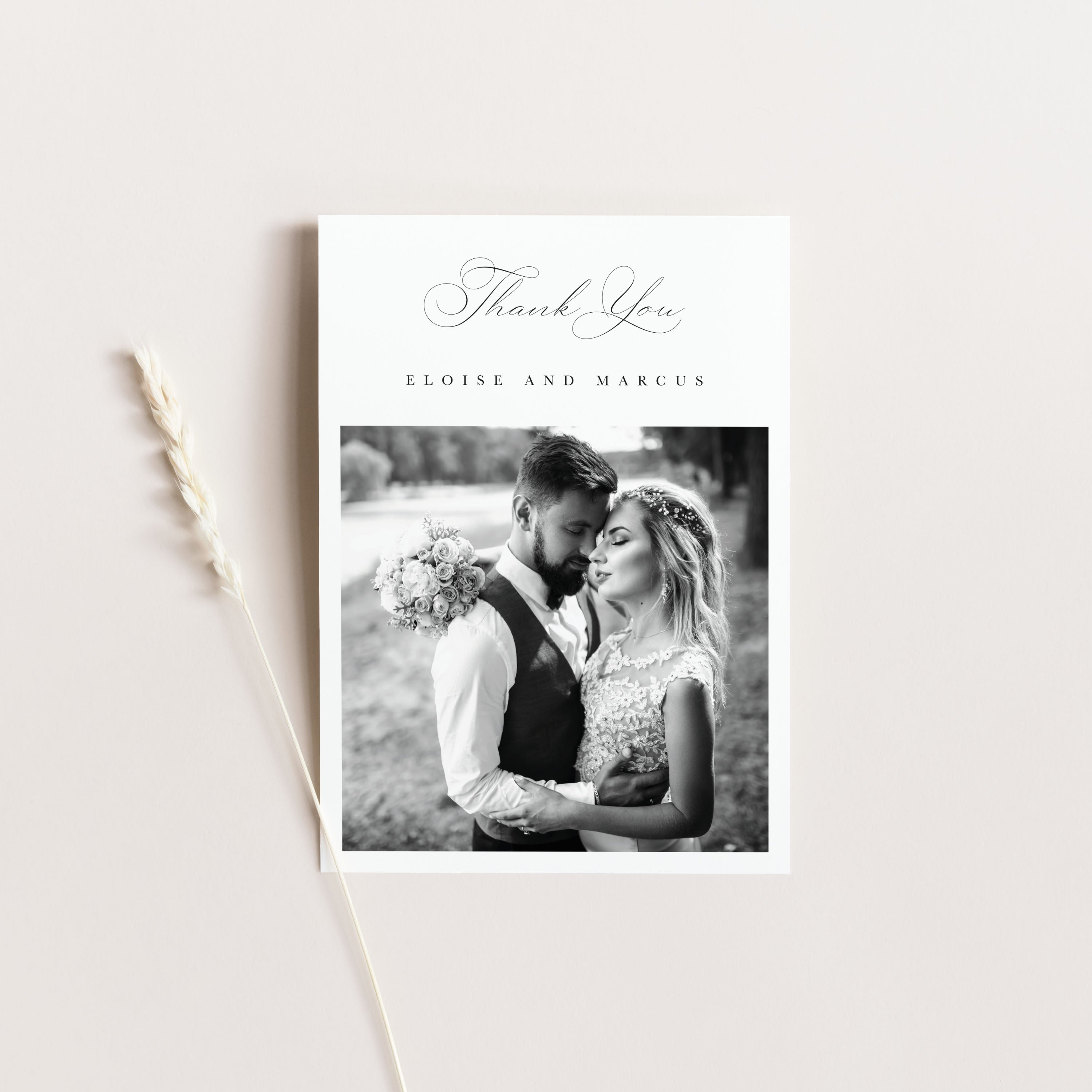 Wedding thank you card with a black and white photo of a couple on a light gray background.