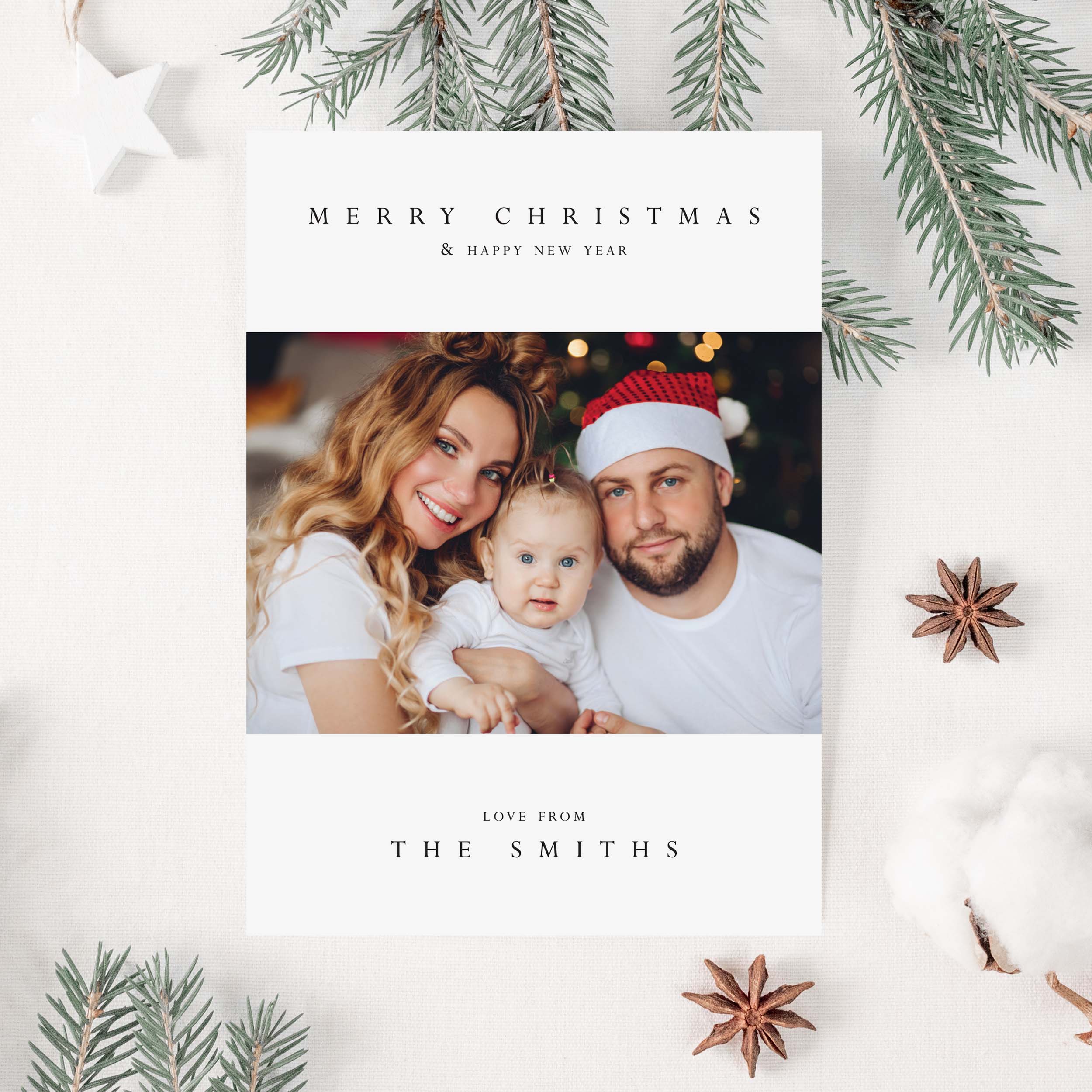 Christmas card with a family photo and festive text on a white background with Christmas decorations.