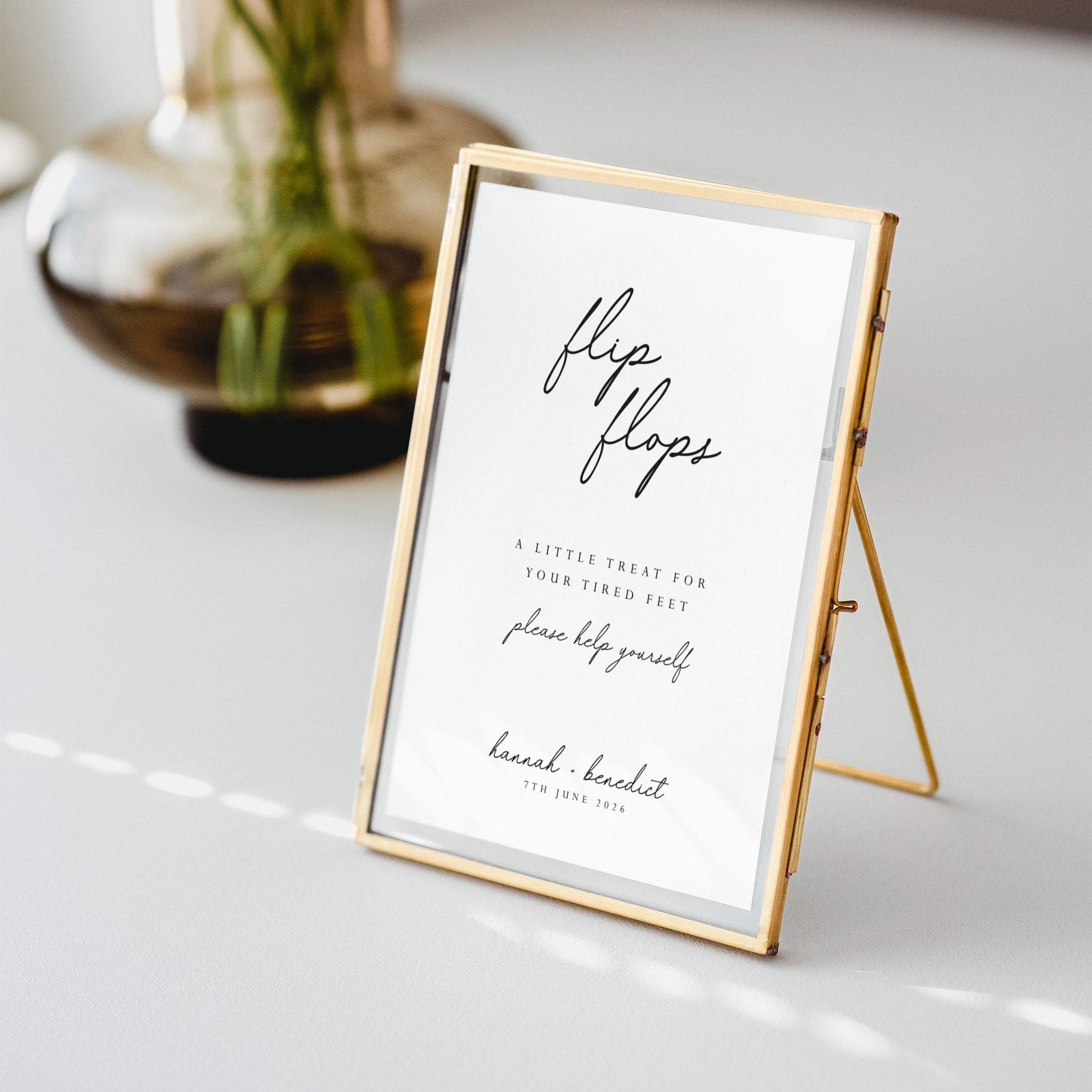 Gold-framed sign on a white surface with text about flip-flops.