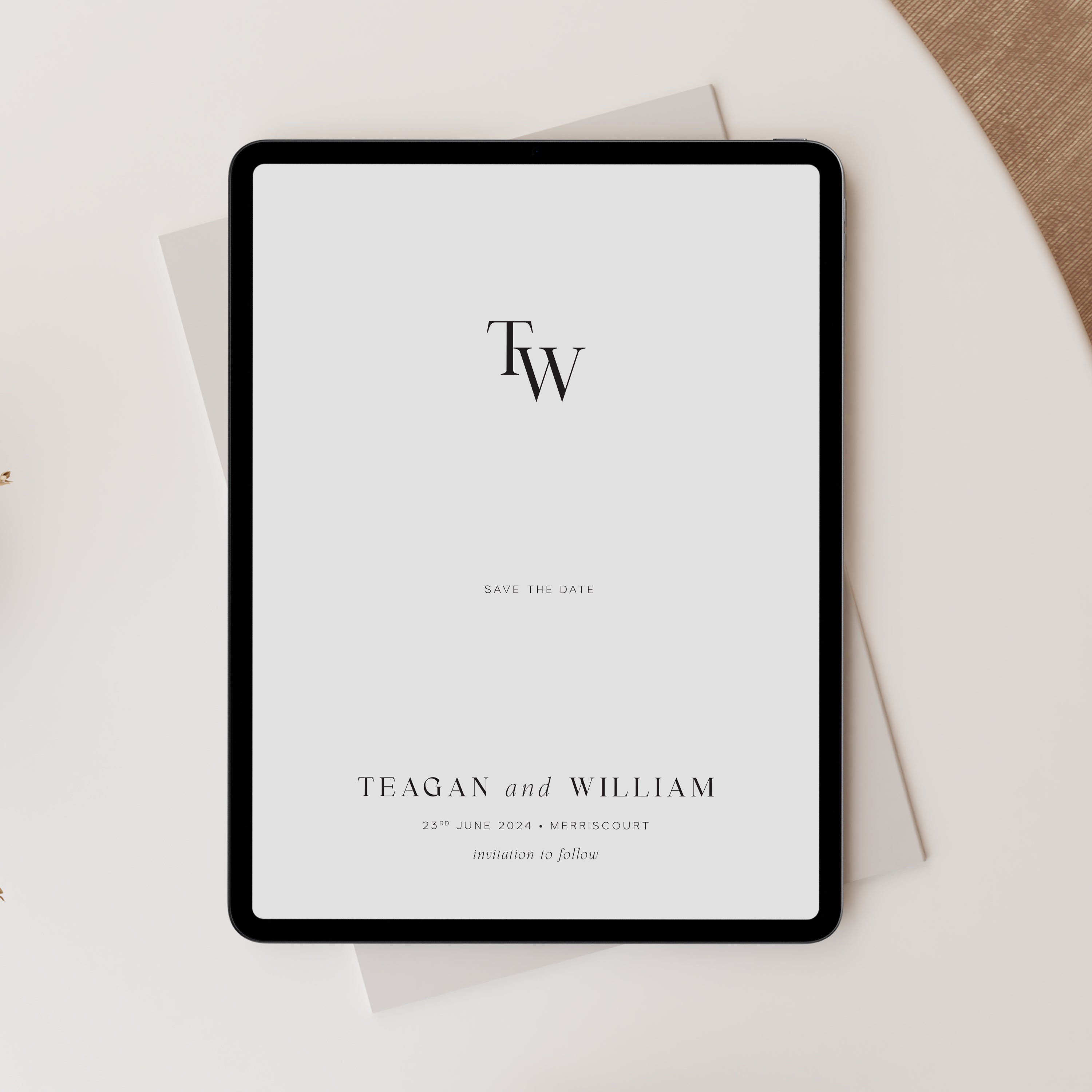 Digital tablet displaying a 'Save the Date' invitation with initials TW on a light surface.