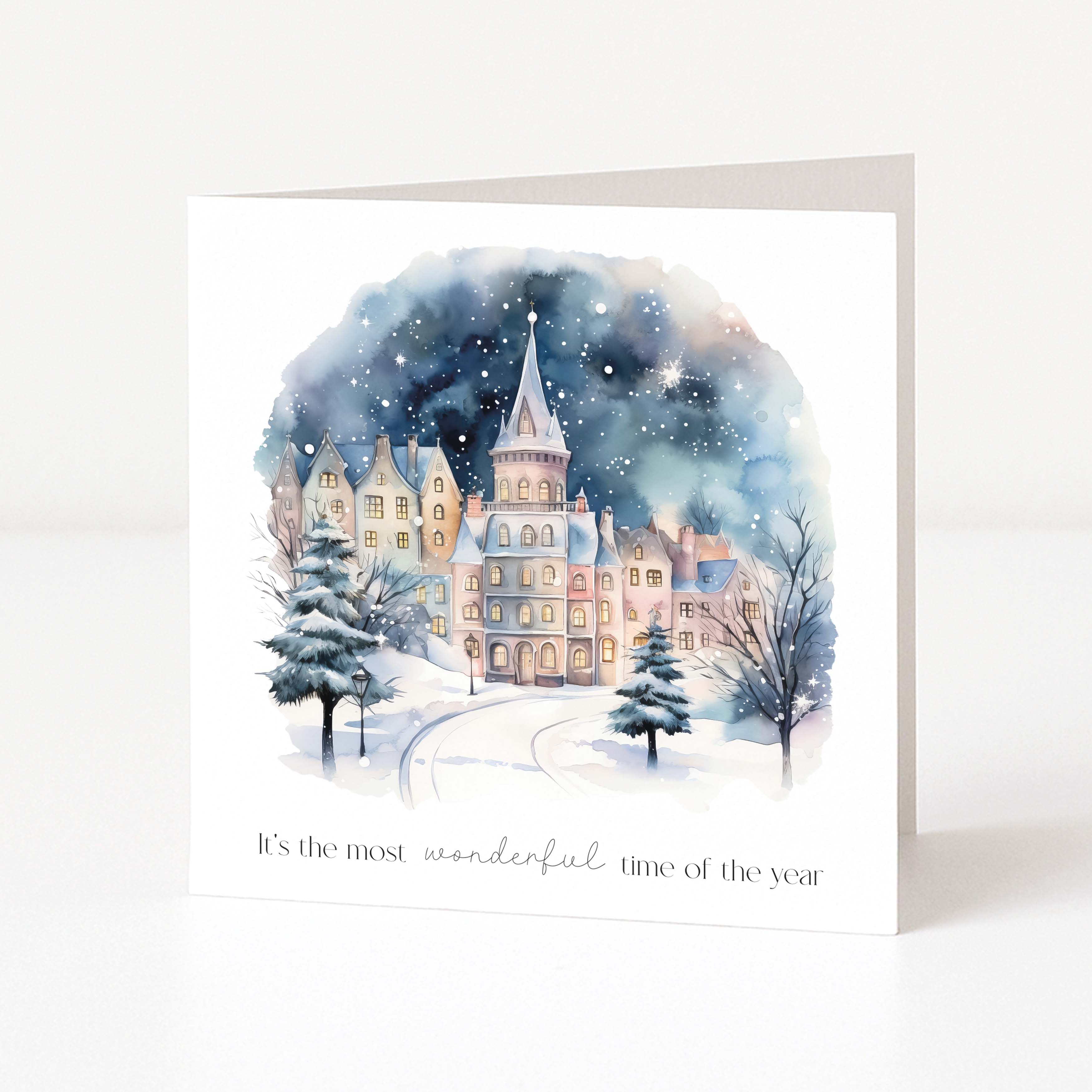 Christmas card with a snowy village scene and text 'It's the most wonderful time of the year' on a white background.