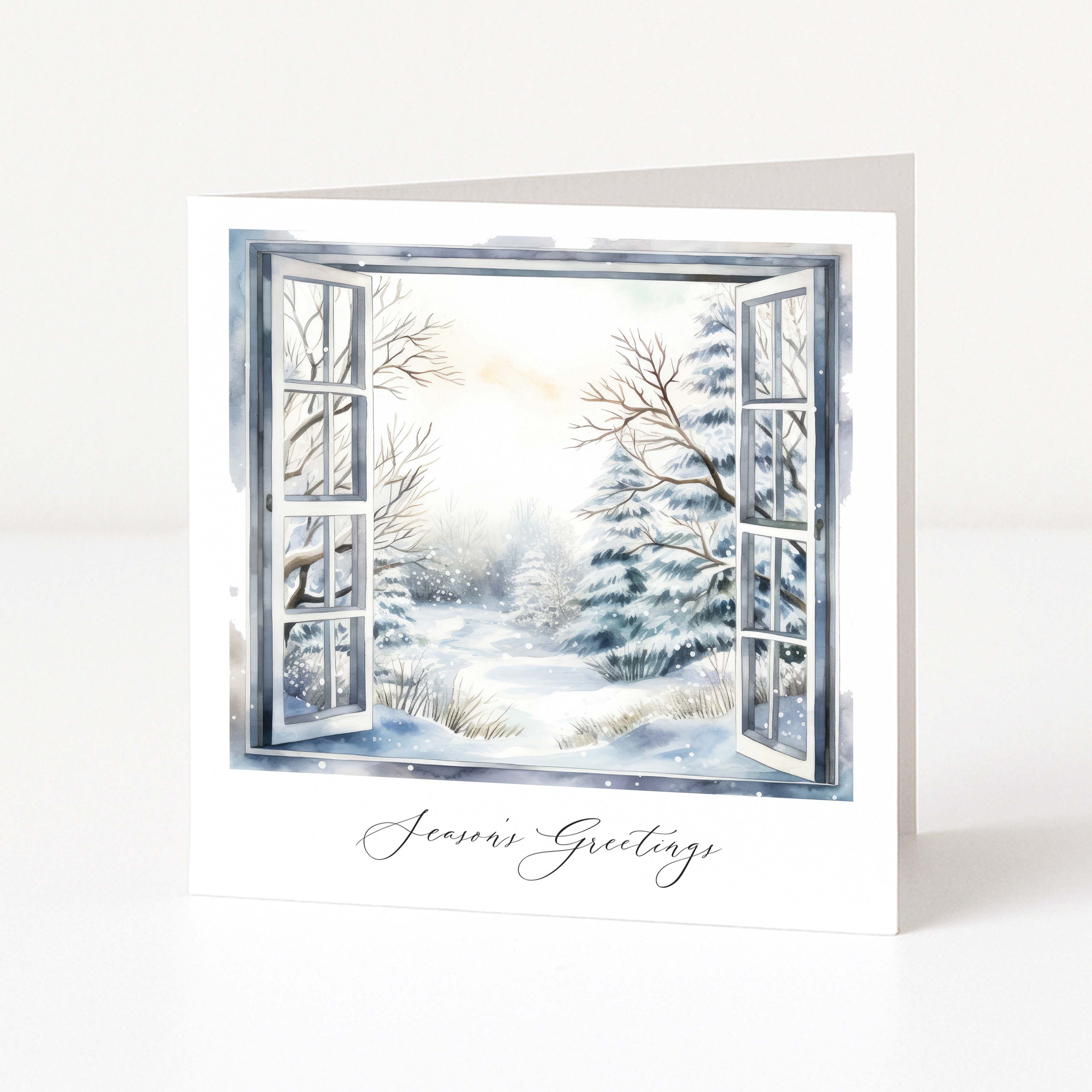 A white greeting card standing upright, printed with an open window view of a snowy winter landscape and the words 'Season's Greetings' in black script at the bottom.