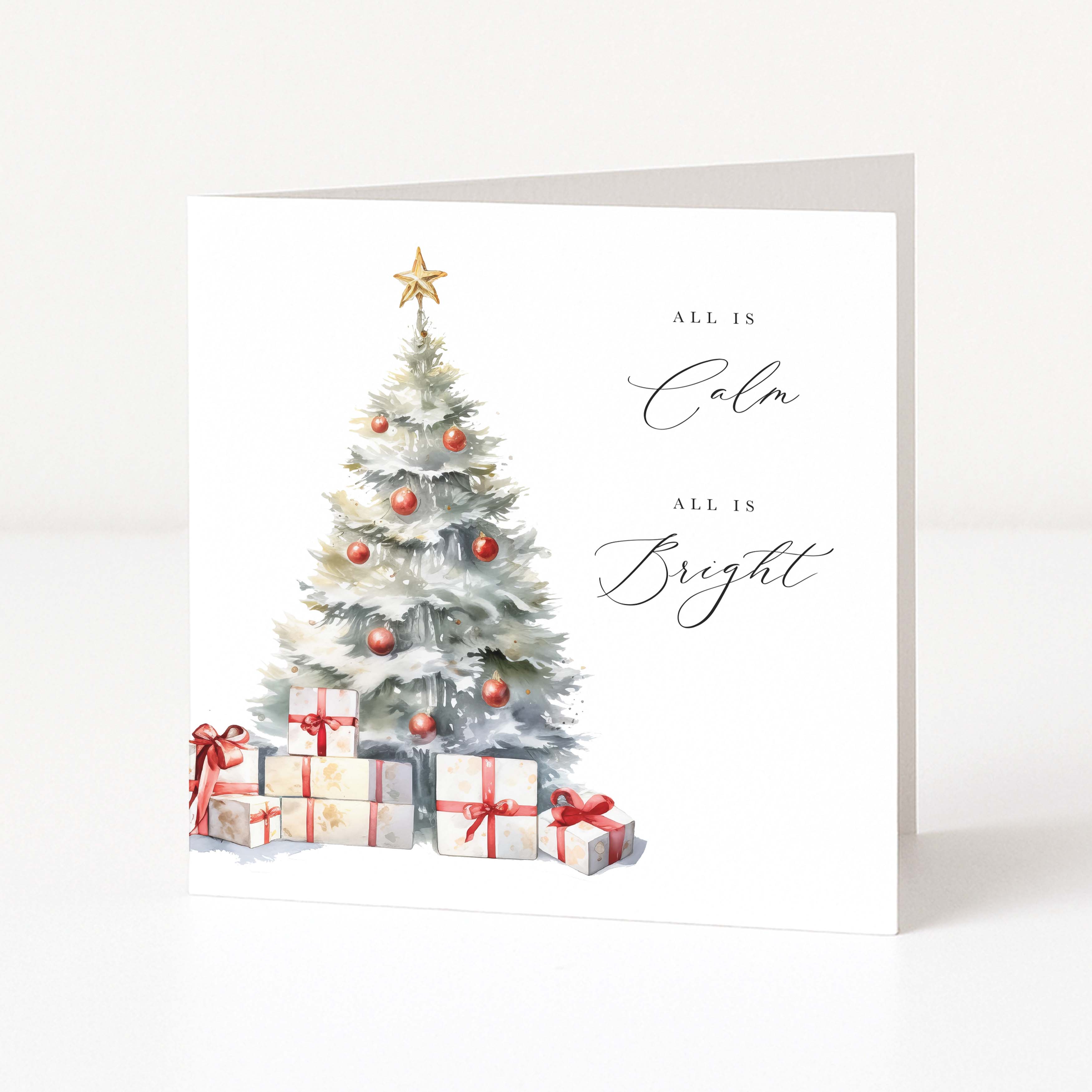 A white Christmas greeting card featuring a watercolor-style Christmas tree with red ornaments, wrapped gifts, and the words 'ALL IS Calm' and 'ALL IS Bright' in black script, shown standing against a clean white background.