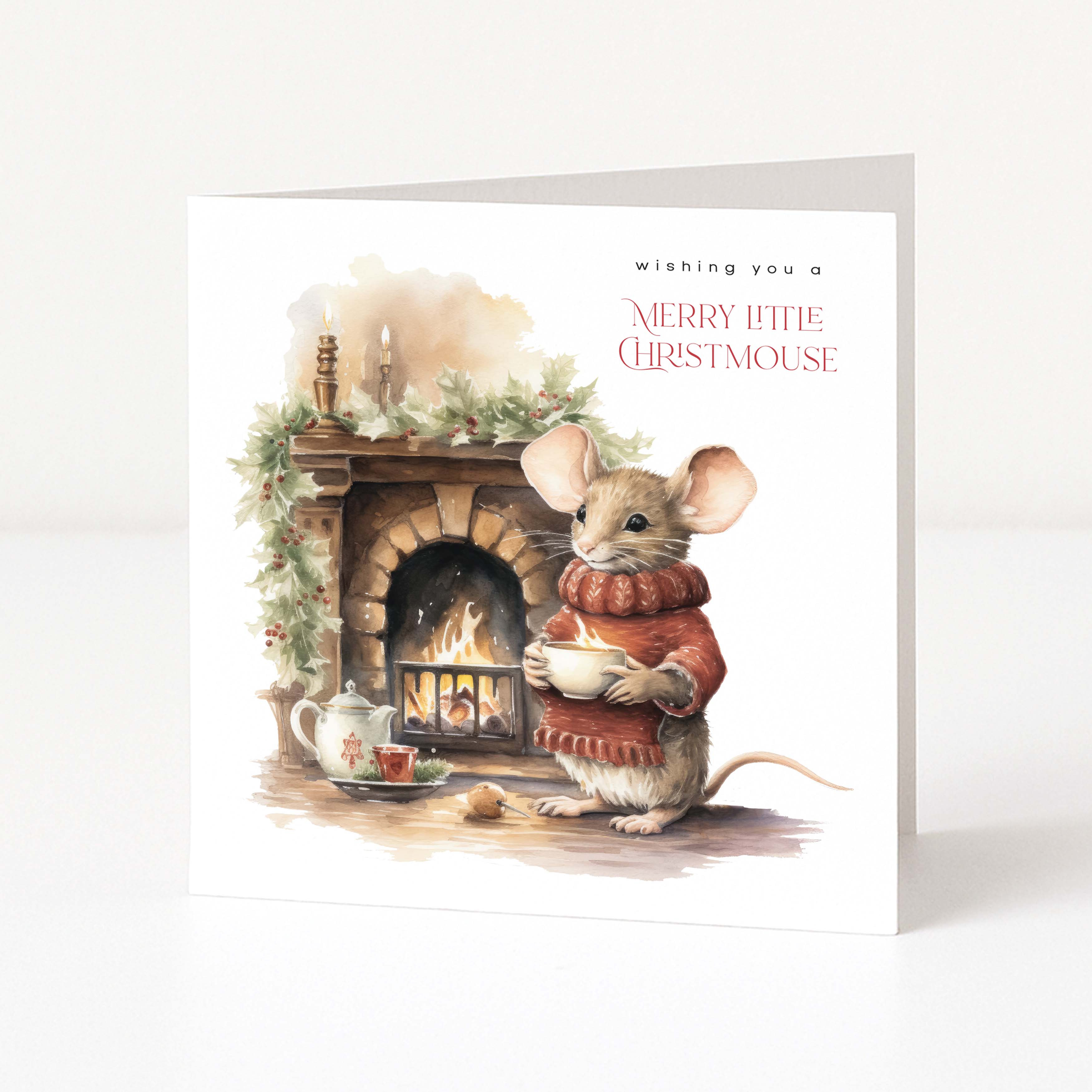 Illustrated Christmas greeting card with an anthropomorphic mouse standing beside a fireplace with the text "wishing you a merry little christmouse" printed.