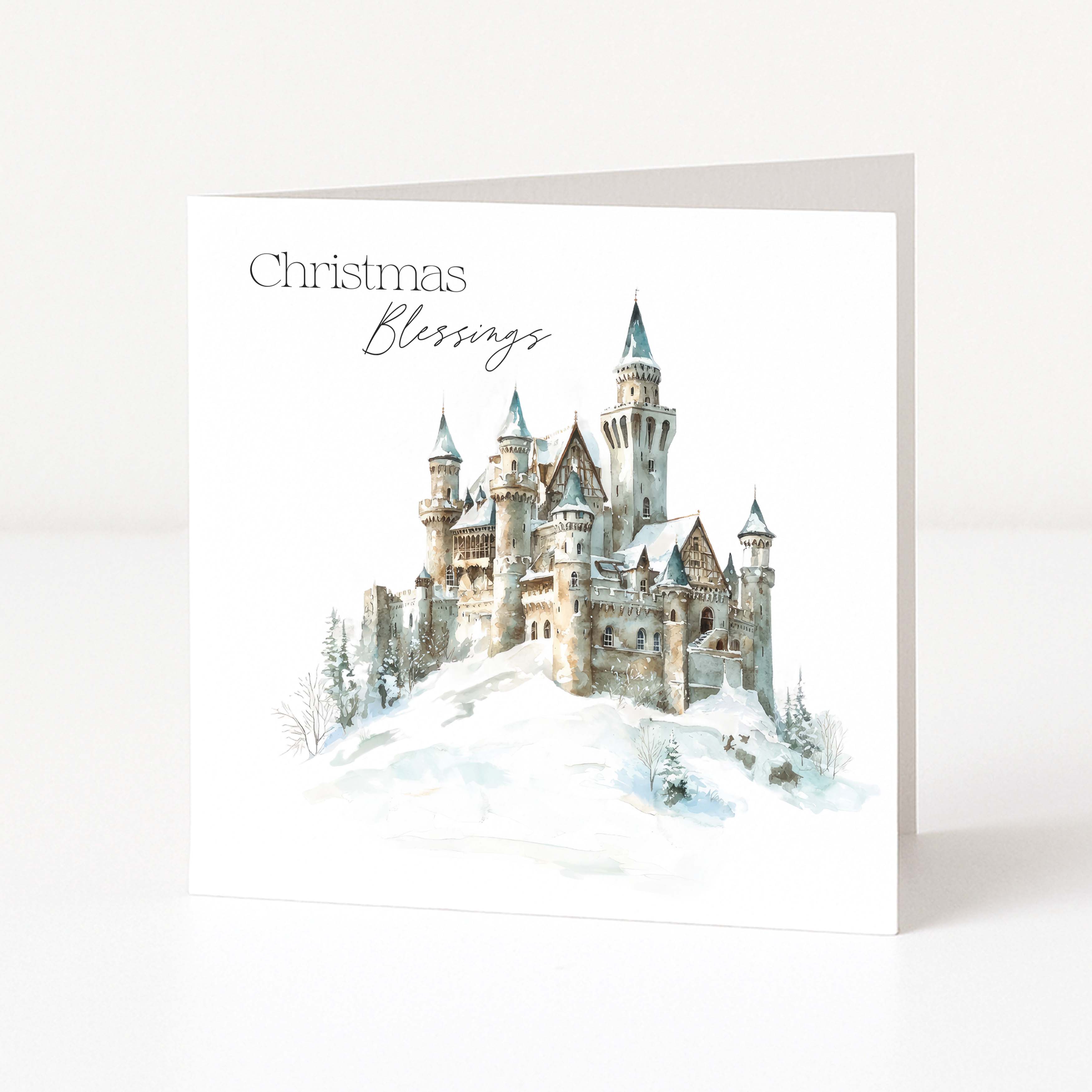A square Christmas greeting card standing upright on a white surface. The front of the card shows a watercolor-style illustration of a snowy castle with the words 'Christmas Blessings' printed above it.