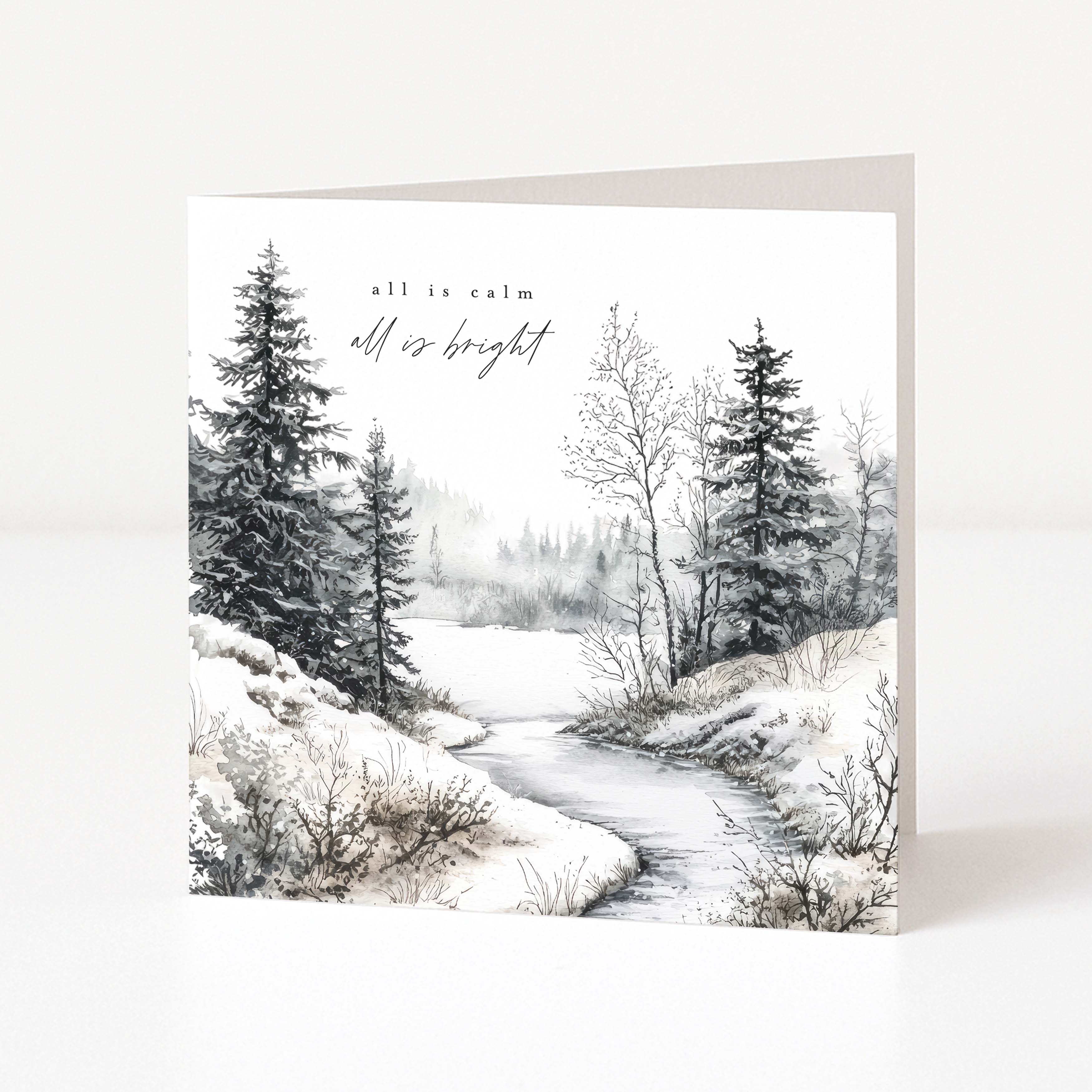 A square Christmas greeting card with a winter landscape illustration, featuring snow-covered trees and a winding stream with the words 'all is calm all is bright' printed at the top. The card is shown standing upright against a clean white background.