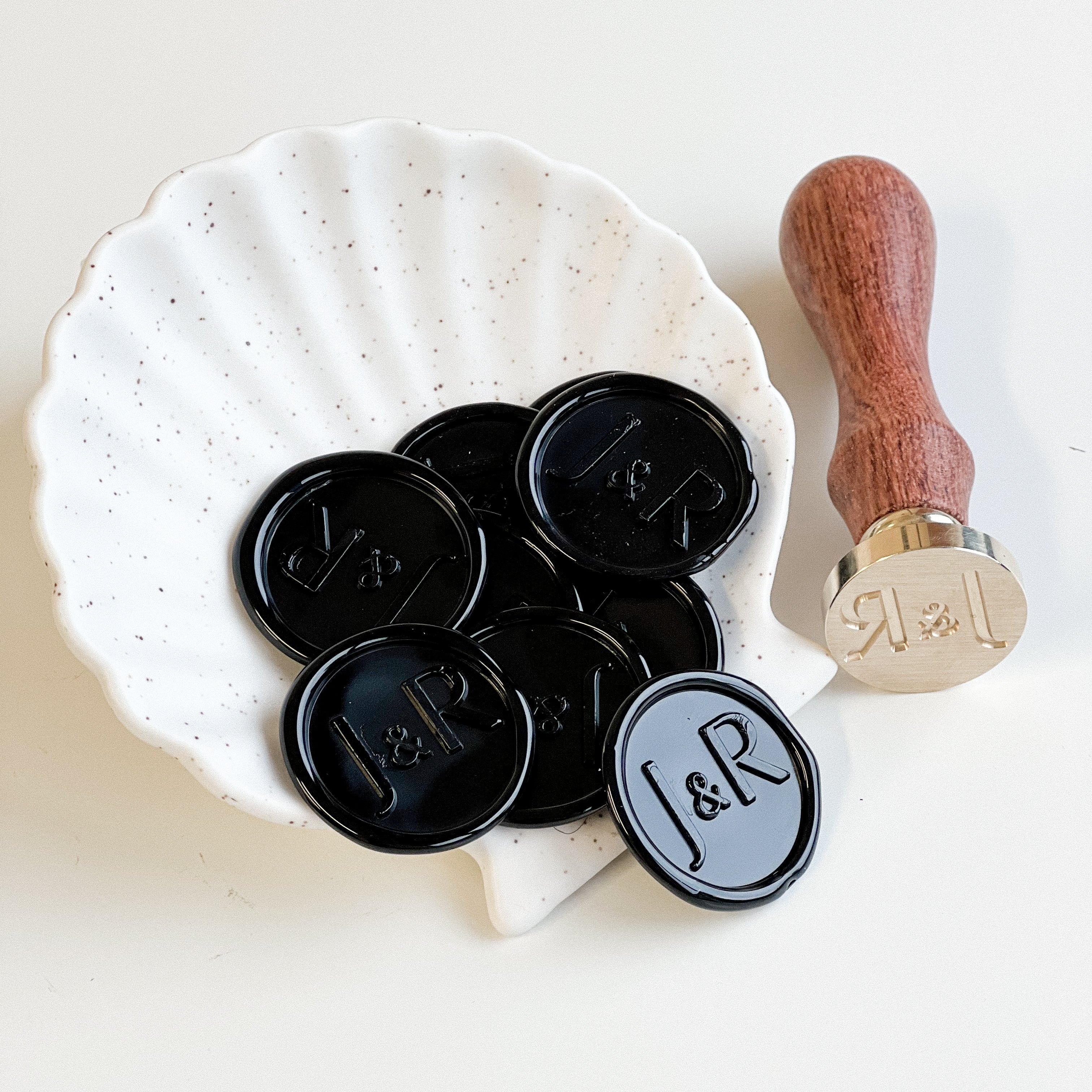 Close up of black wedding wax seals, adding a luxurious and classic touch to wedding invitations