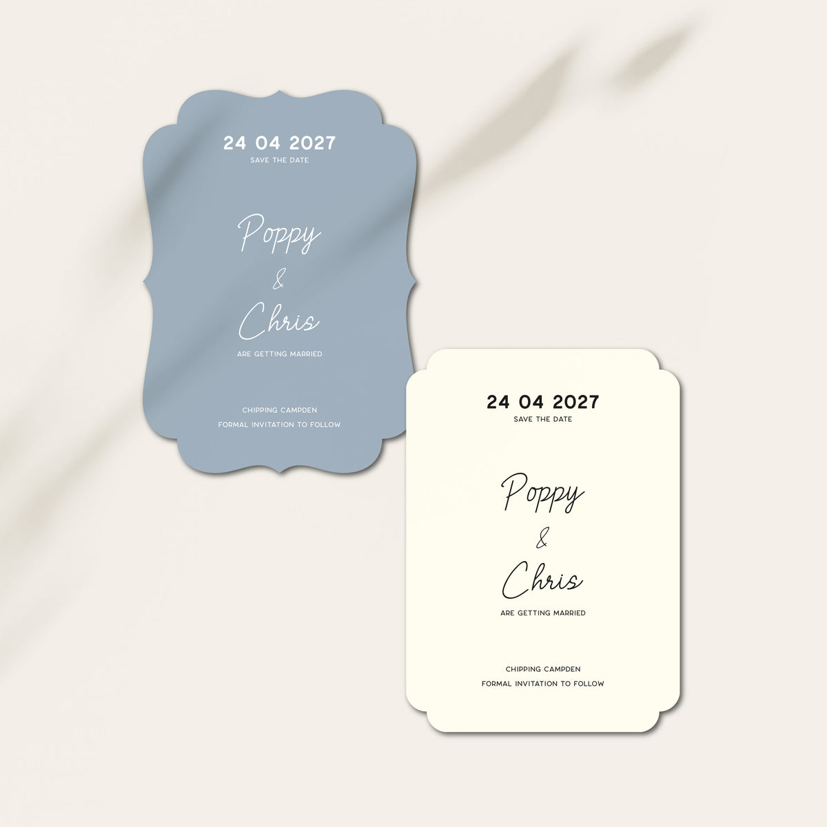 A wedding save-the-date card set on a light beige background with soft gray shadows. The set includes a dusty blue scalloped card reading '24 04 2027 Poppy & Chris Are Getting Married' and a cream-colored matching card with black script text.