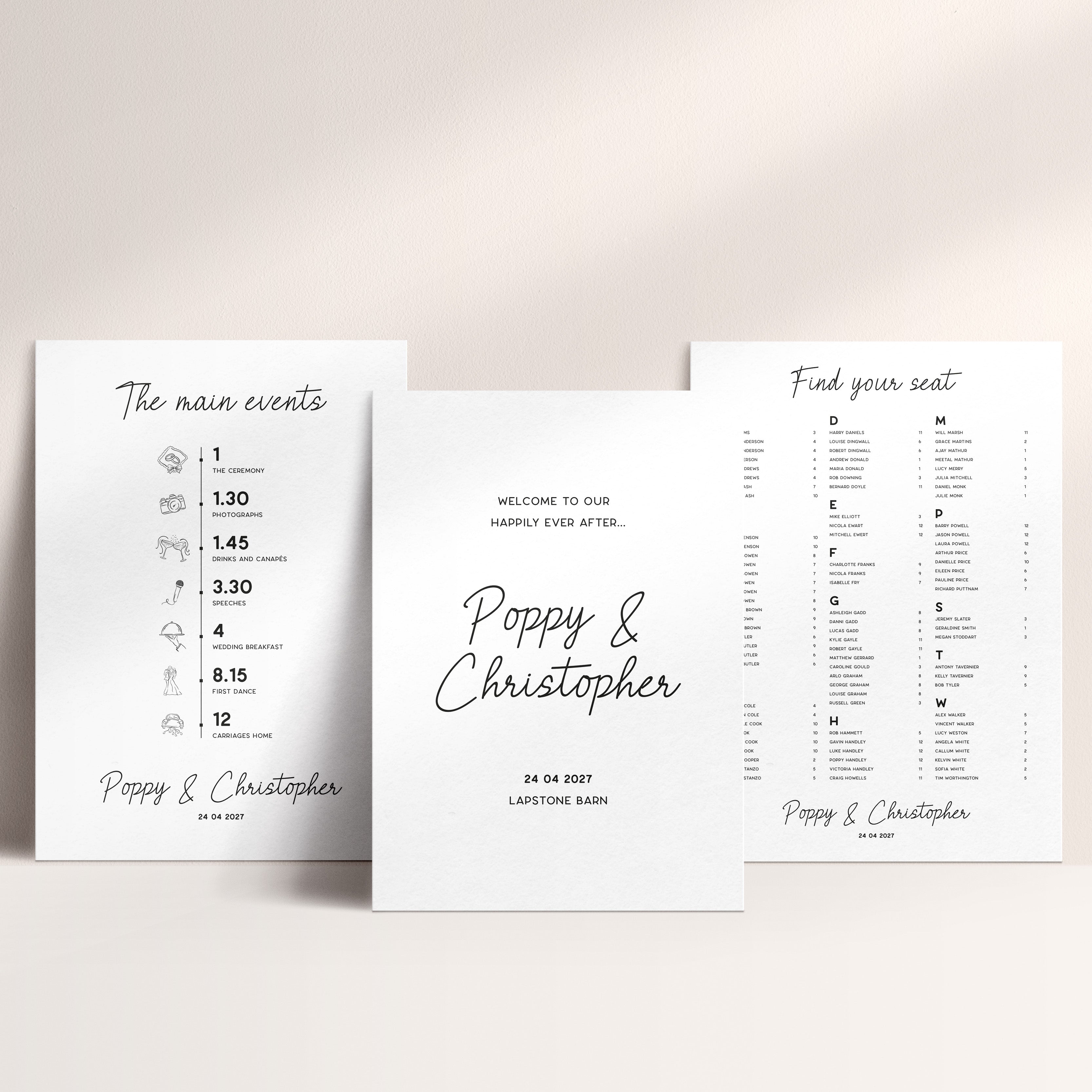 Three white wedding signs arranged on a light beige background. The centre sign reads 'Welcome to our happily ever after.