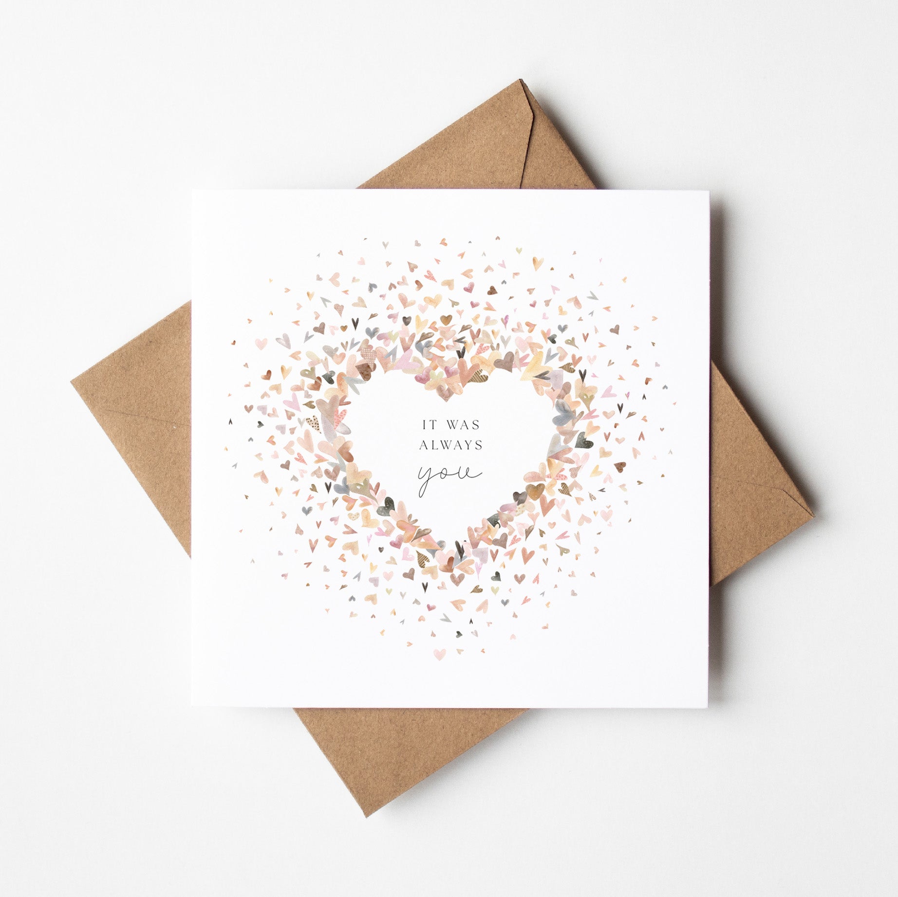 Greeting card with confetti heart design and brown envelope on white background