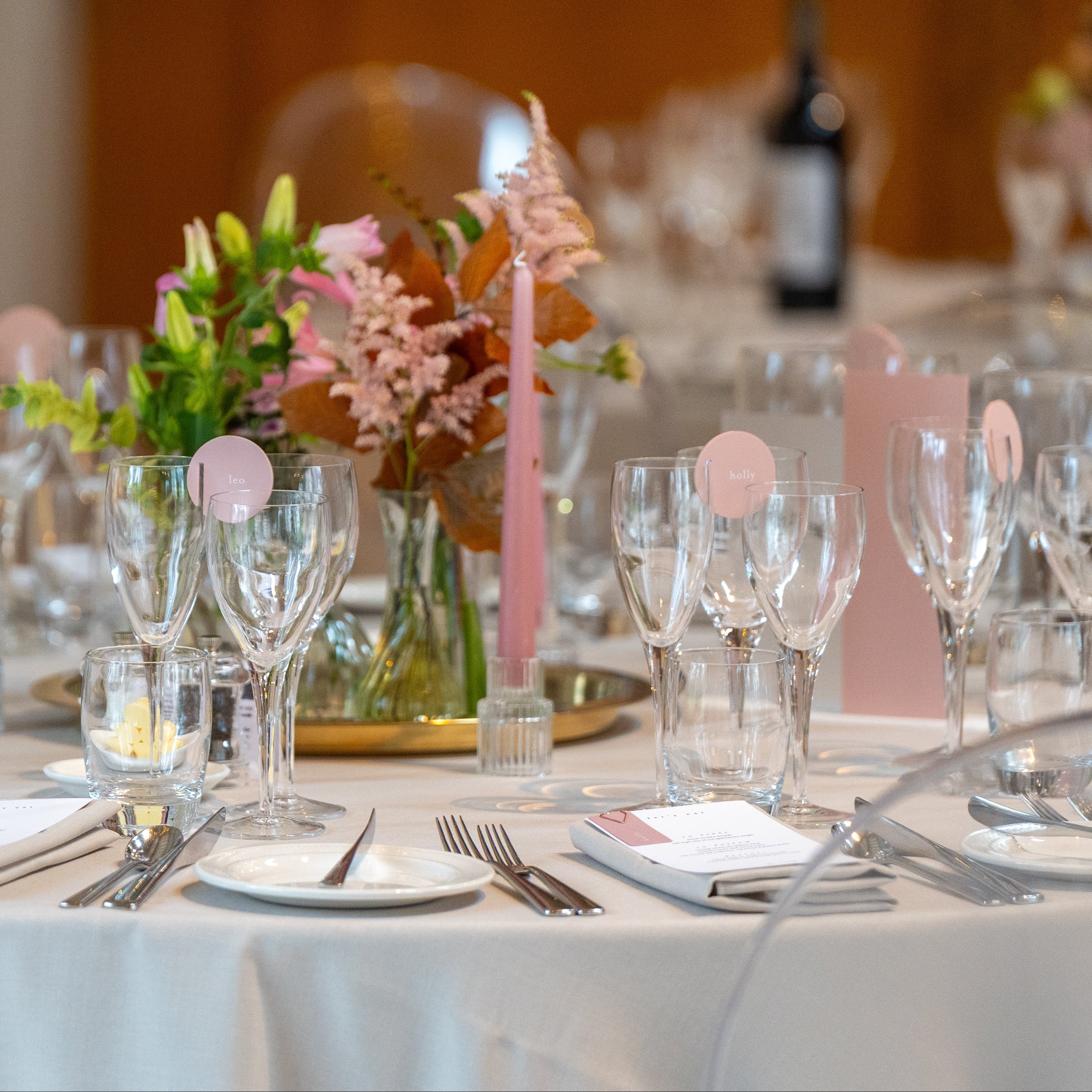 Decorated table with wine glasses, flowers, and candles in a formal setting.