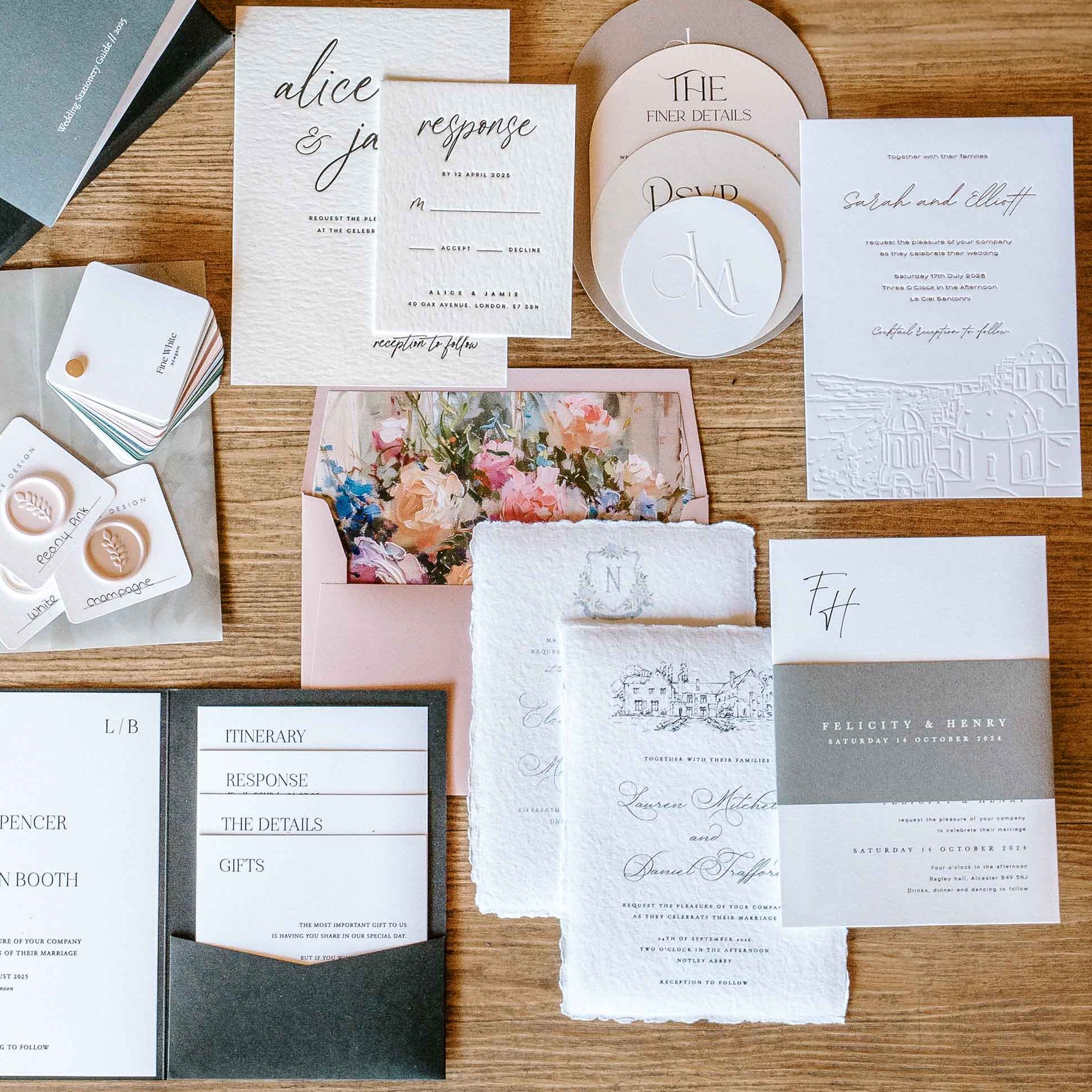 Collection of wedding invitations and stationery items on a wooden surface