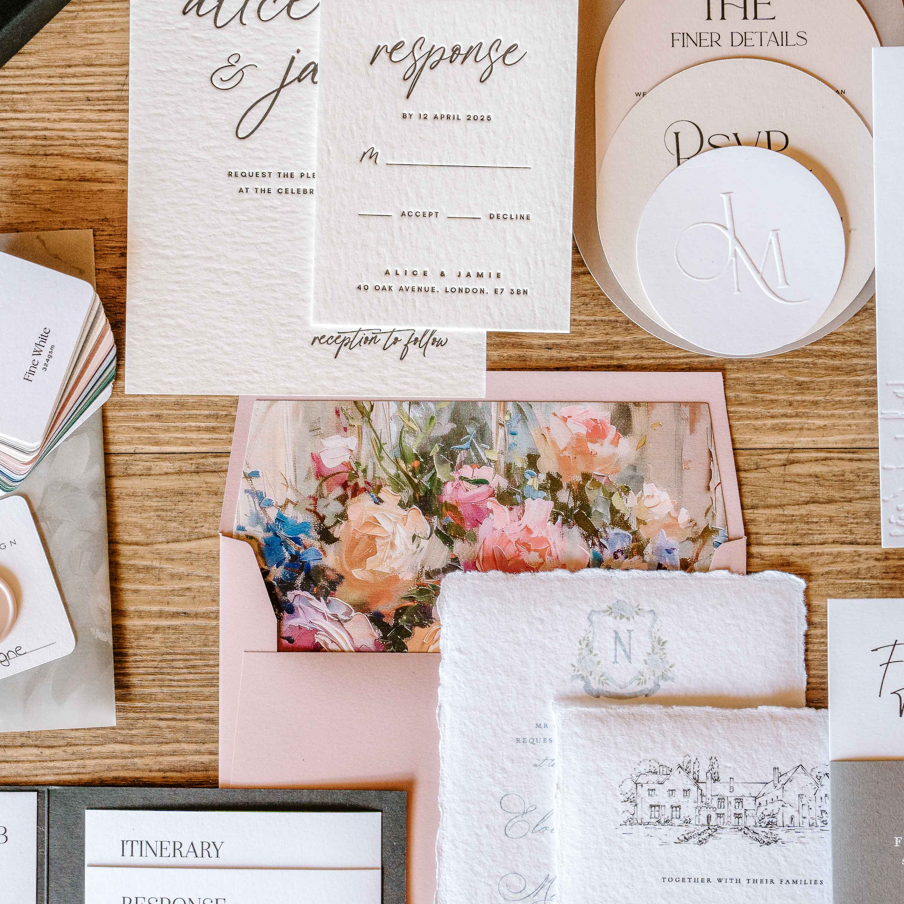 Wedding invitation set with floral design on a wooden surface