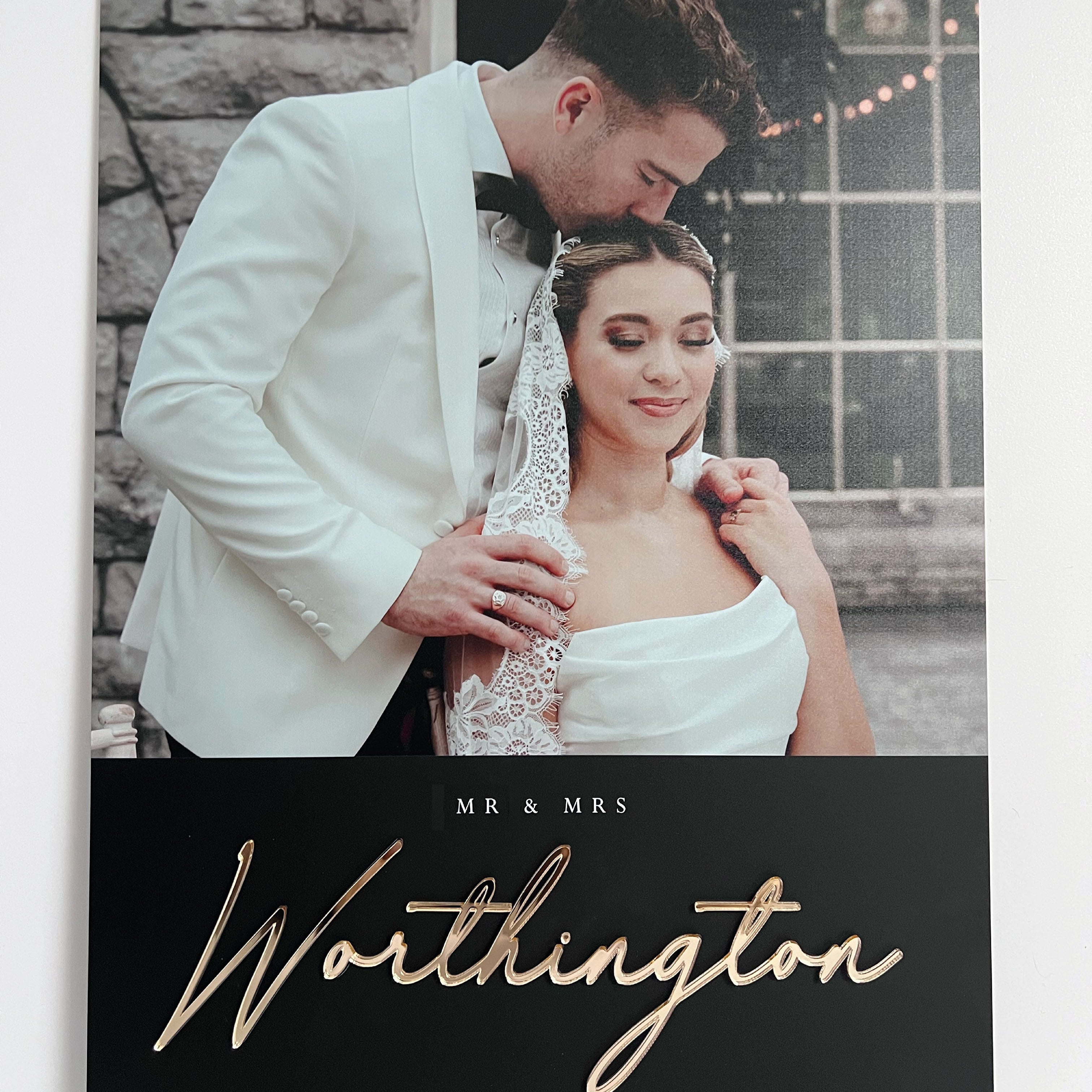 Wedding photo on black acrylic of a couple with 'MR & MRS Worthington' gold text on a black background