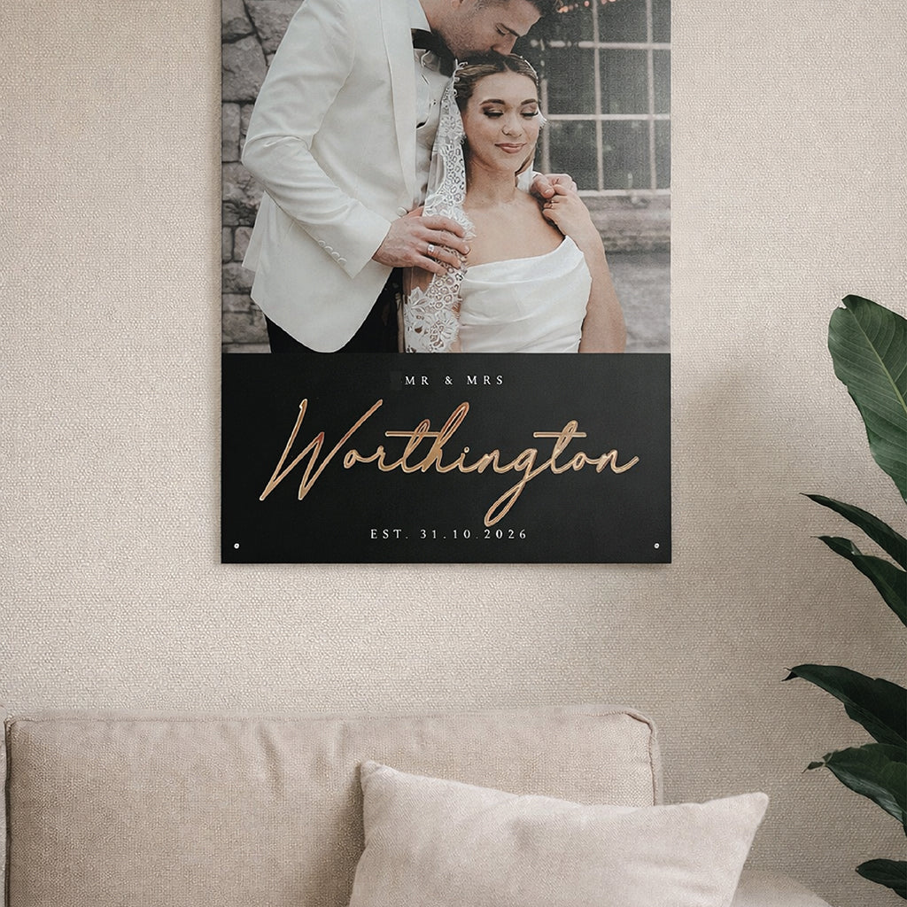 Wall art with a couple and text on a beige wall above a sofa.