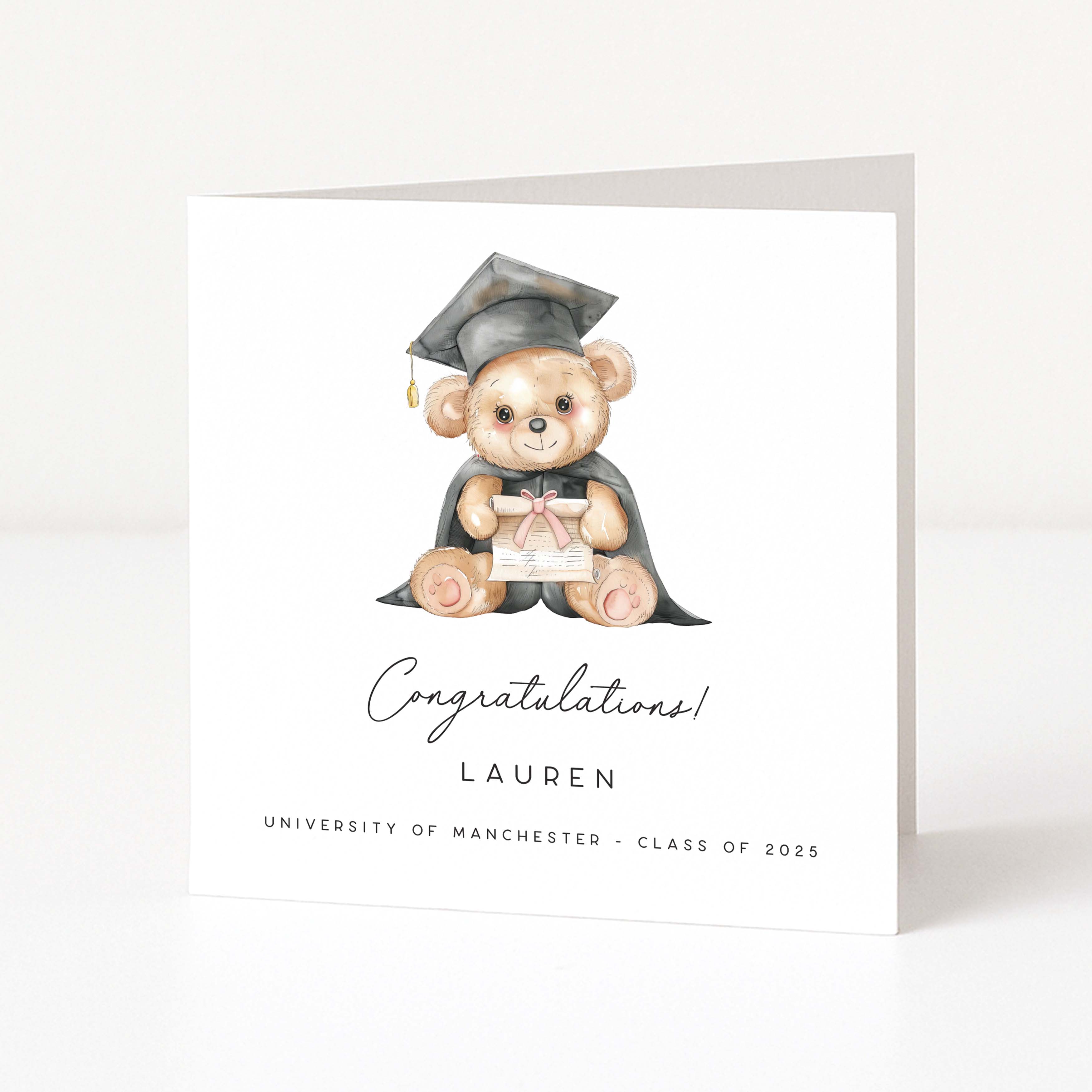 Graduation-themed card with a teddy bear in a mortarboard and gown on a white background