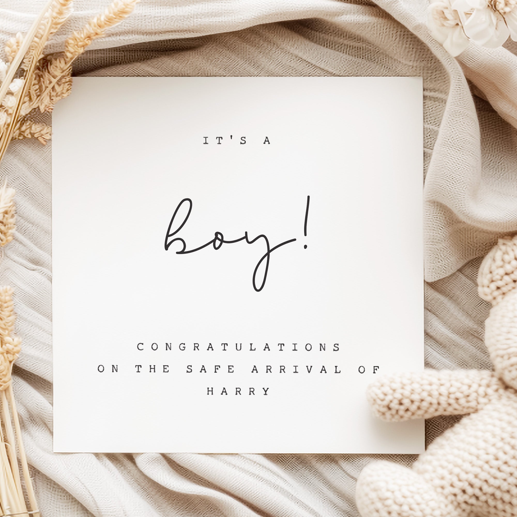 Newborn baby boy arrival card with decorative elements on a soft fabric background
