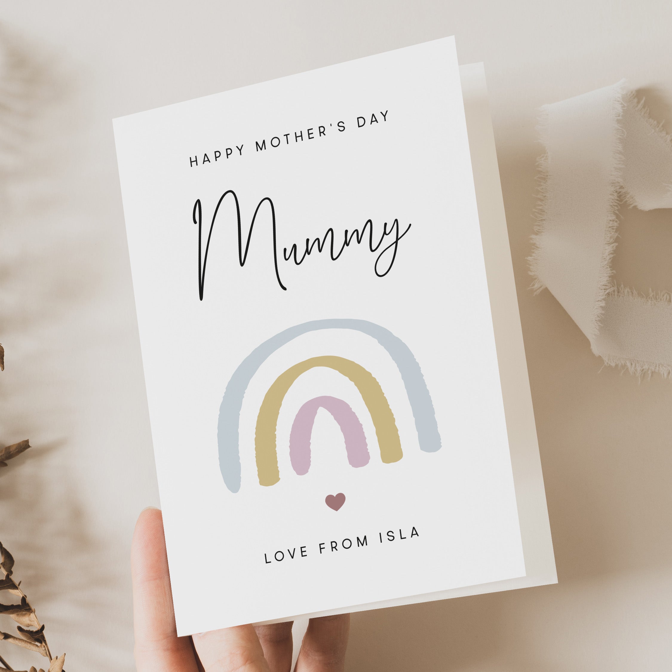 Mother's Day card with rainbow design held by a hand on a soft background