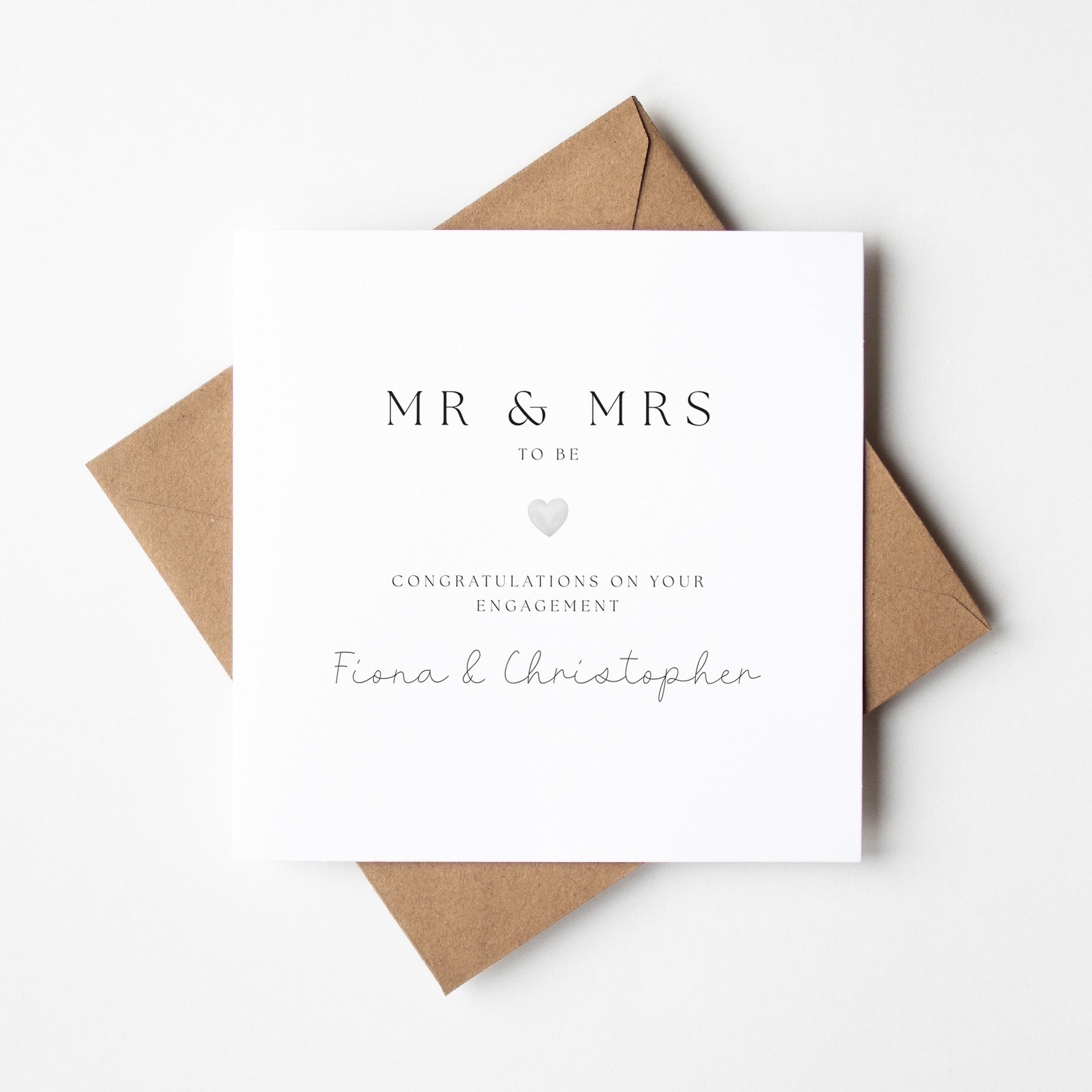 Engagement card with 'MR & MRS TO BE' text and a brown envelope on a white background