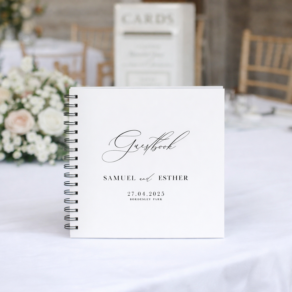 White square guest book with black ring binder, on a wedding table with flowers and wedding post box