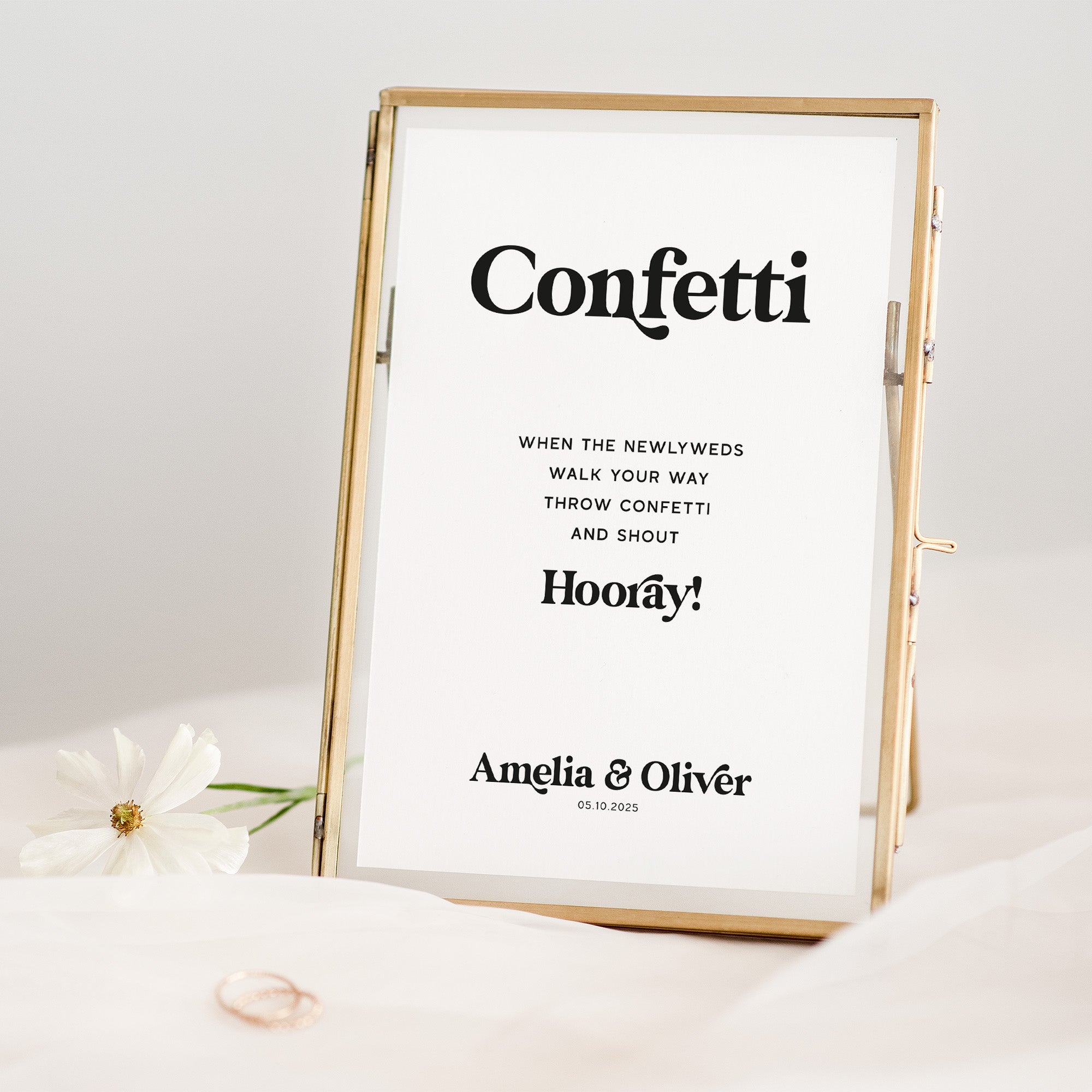 Decorative sign with confetti message and personalized names in a gold frame.